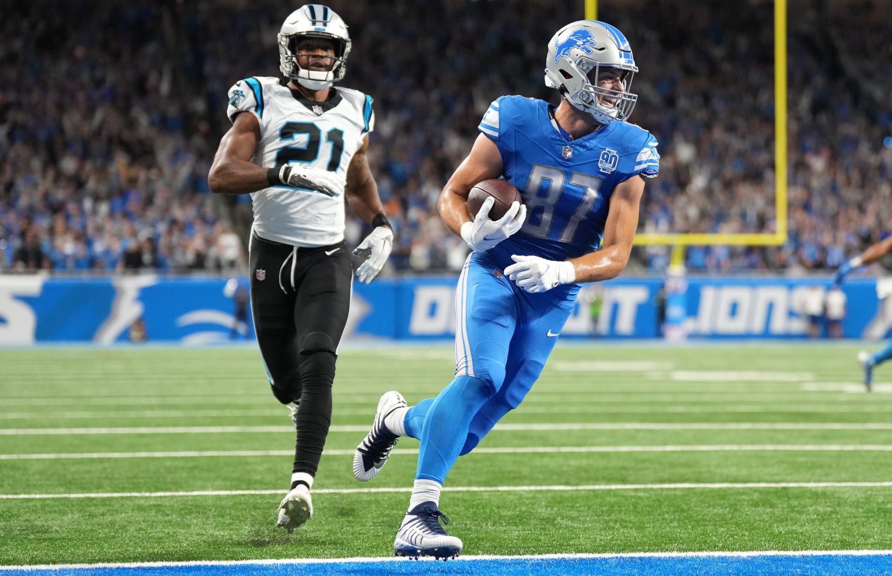 DETROIT, MICHIGAN - OCTOBER 08: Sam LaPorta #87 of the Detroit Lions scores a touchdown past Jeremy Chinn #21 of the Carolina Panthers in the second quarter at Ford Field on October 08, 2023 in Detroit, Michigan. (Photo by Nic Antaya/Getty Images)