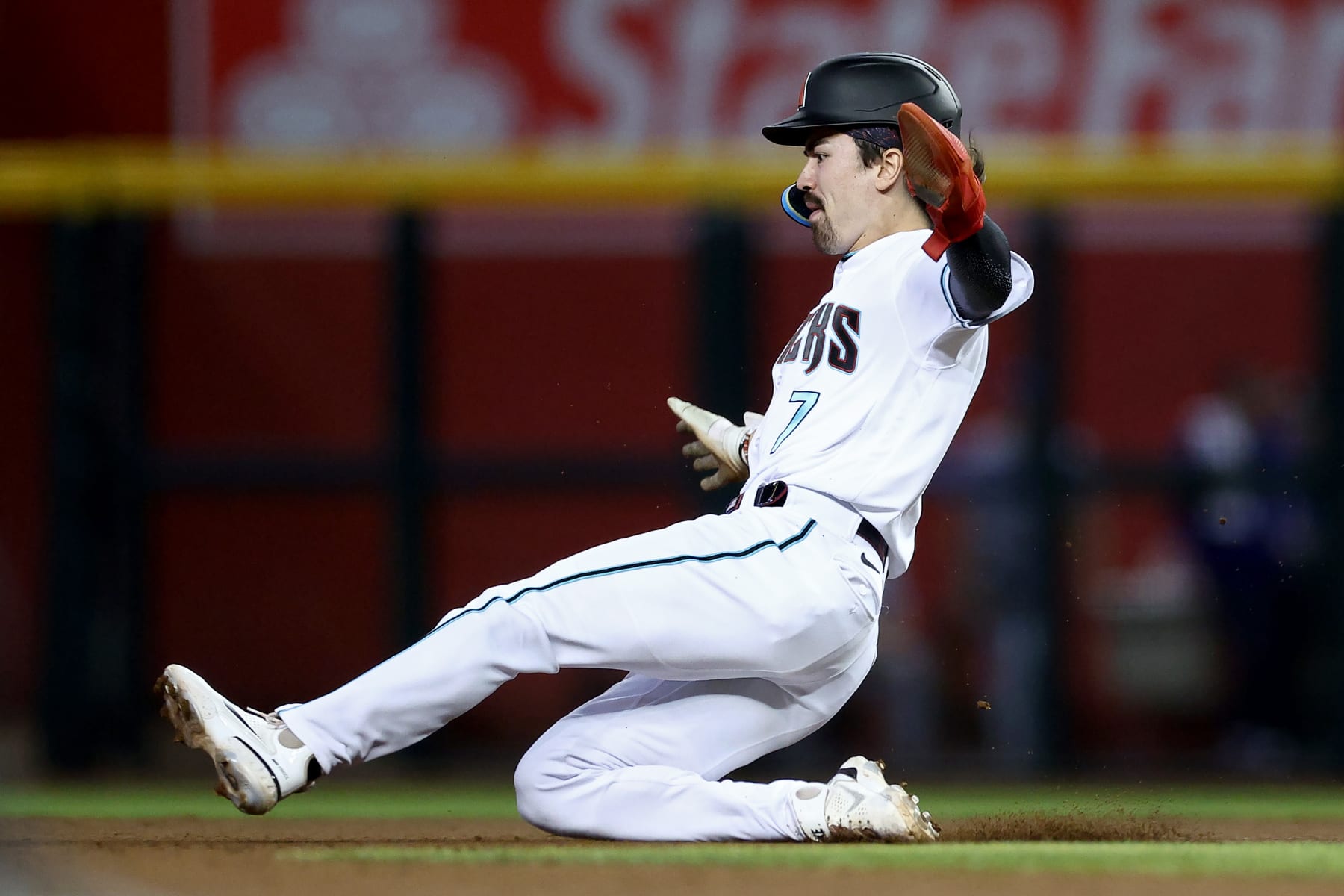 PHOENIX, ARIZONA - OCTOBER 11: Corbin Carroll #7 of the Arizona Diamondbacks slides into second base for a stolen base in the fifth inning against the Los Angeles Dodgers during Game Three of the Division Series at Chase Field on October 11, 2023 in Phoenix, Arizona. (Photo by Elsa/Getty Images)