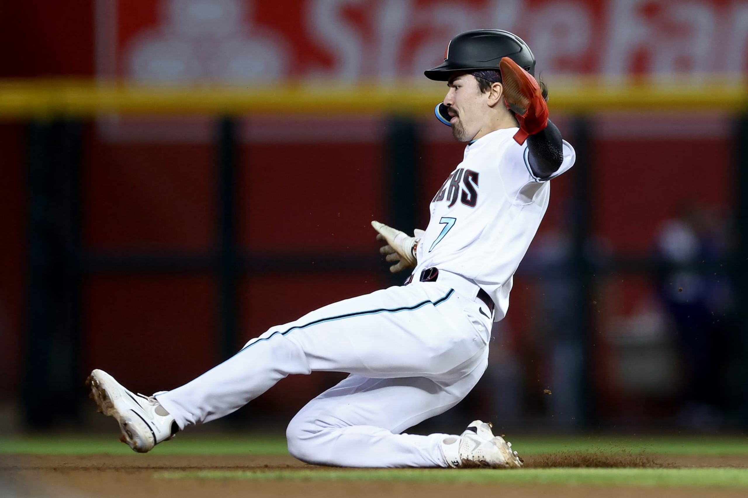PHOENIX, ARIZONA - OCTOBER 11: Corbin Carroll #7 of the Arizona Diamondbacks slides into second base for a stolen base in the fifth inning against the Los Angeles Dodgers during Game Three of the Division Series at Chase Field on October 11, 2023 in Phoenix, Arizona. (Photo by Elsa/Getty Images)