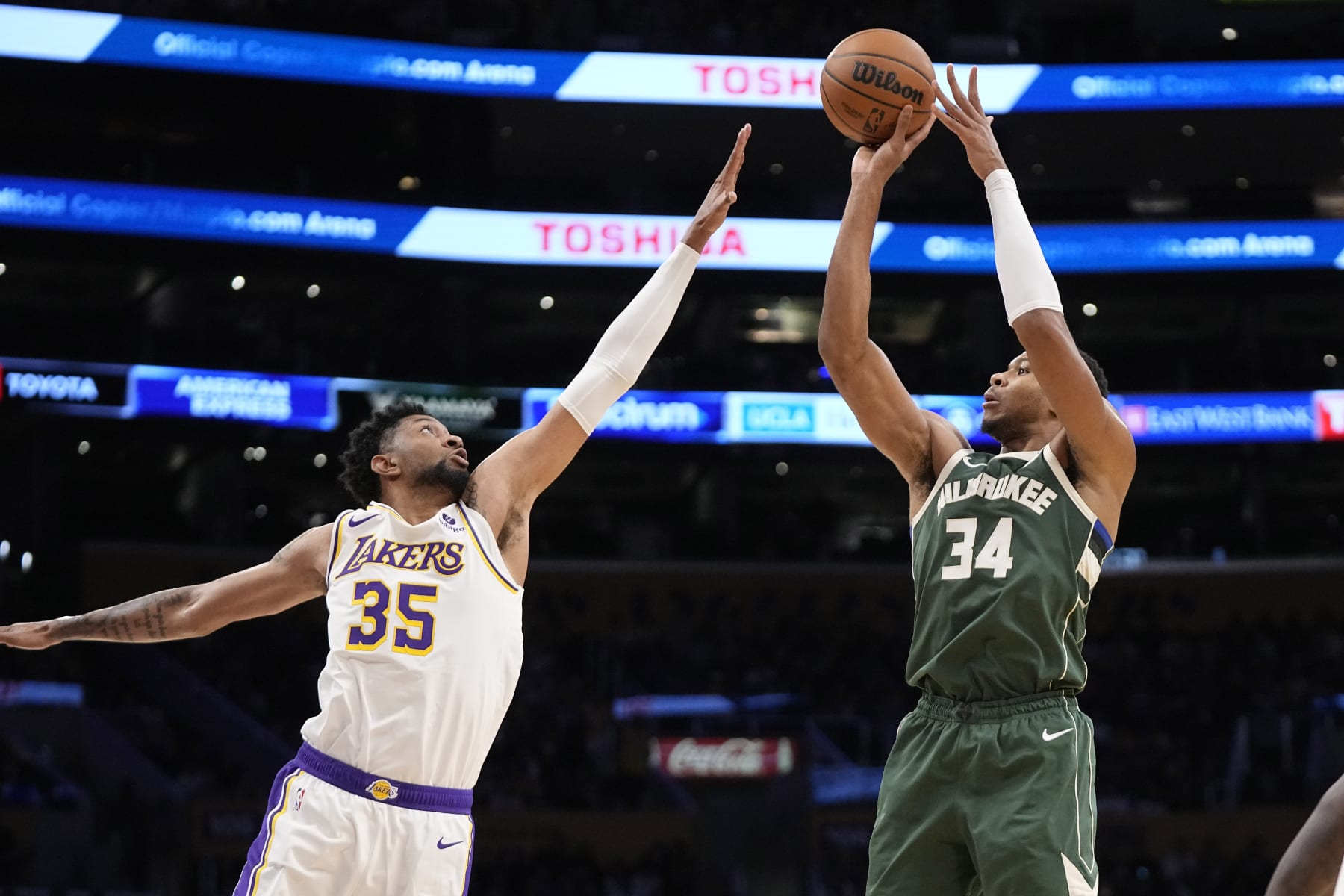 Milwaukee Bucks forward Giannis Antetokounmpo, right, shoots as Los Angeles Lakers forward Christian Wood defends during the first half of an NBA preseason basketball game Sunday, Oct. 15, 2023, in Los Angeles. (AP Photo/Mark J. Terrill)
