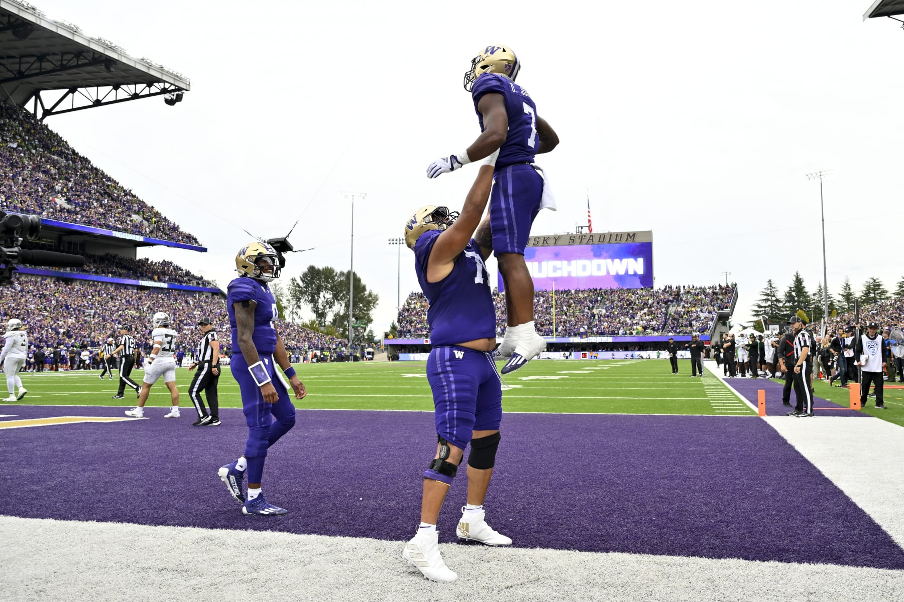 SEATTLE, WASHINGTON - OCTOBER 14: Dillon Johnson #7 of the Washington Huskies celebrates with Nate Kalepo #71 after scoring a touchdown against the Oregon Ducks during the second quarter at Husky Stadium on October 14, 2023 in Seattle, Washington. (Photo by Alika Jenner/Getty Images)