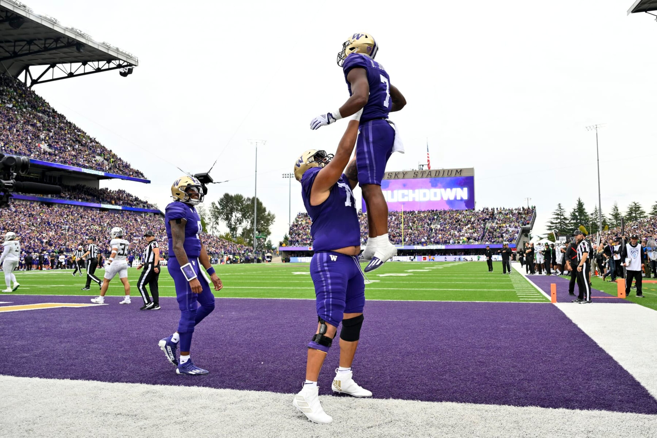 SEATTLE, WASHINGTON - OCTOBER 14: Dillon Johnson #7 of the Washington Huskies celebrates with Nate Kalepo #71 after scoring a touchdown against the Oregon Ducks during the second quarter at Husky Stadium on October 14, 2023 in Seattle, Washington. (Photo by Alika Jenner/Getty Images)