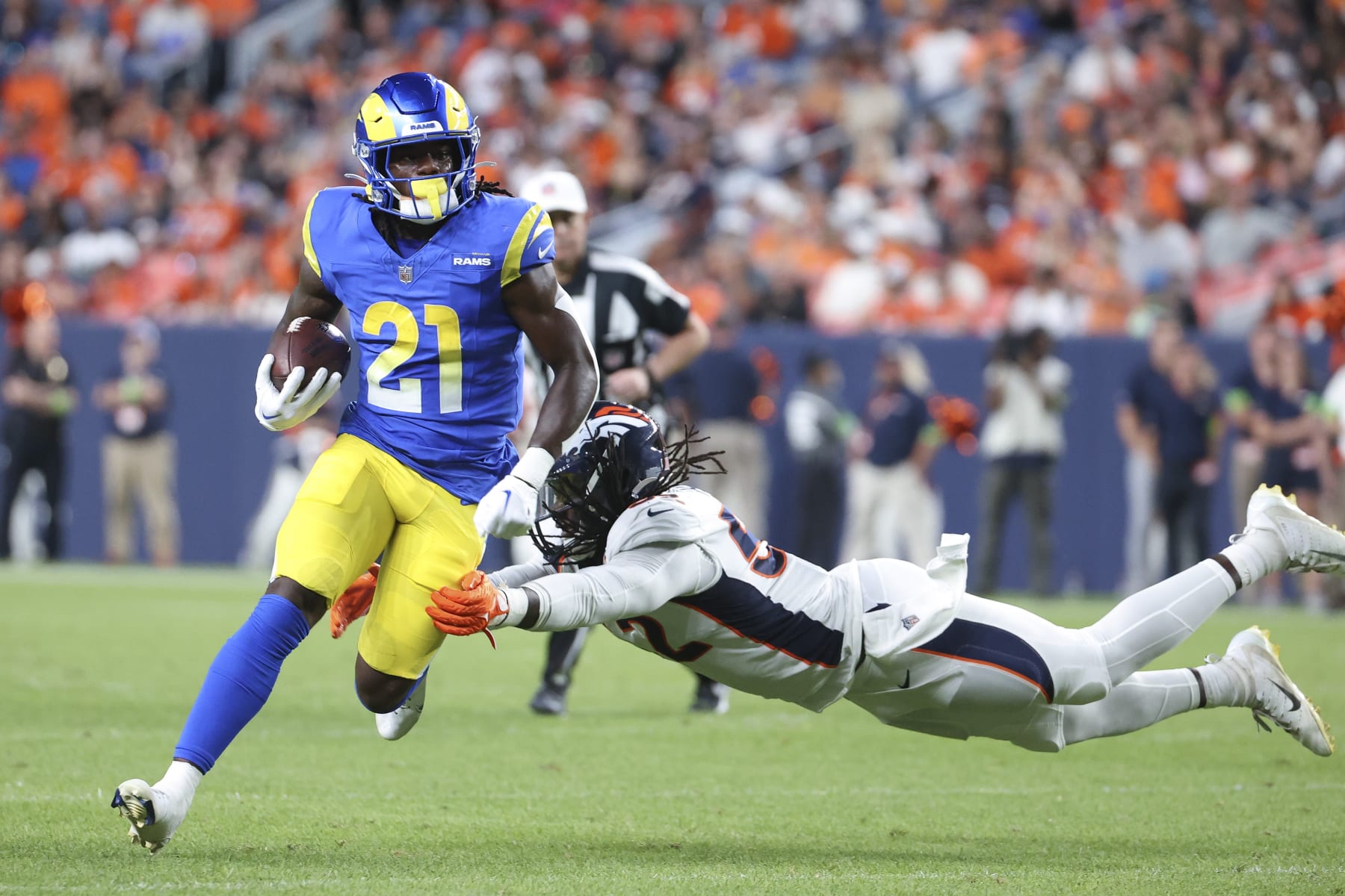 DENVER, COLORADO - AUGUST 26: Marcus Haynes (R) #52 of the Denver Broncos attempts to tackle Zach Evans #21 of the Los Angeles Rams in the second half of the preseason game at Empower Field At Mile High on August 26, 2023 in Denver, Colorado. (Photo by Tyler Schank/Getty Images)