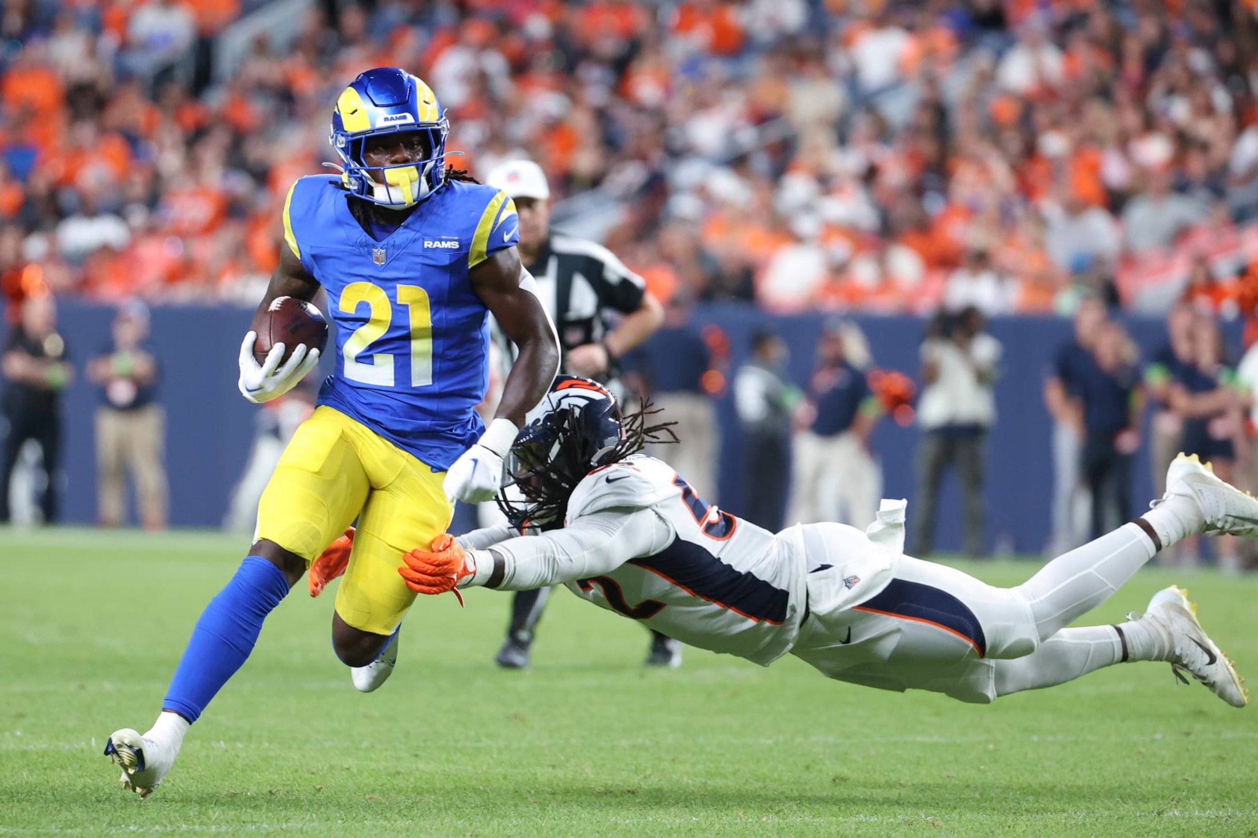 DENVER, COLORADO - AUGUST 26: Marcus Haynes (R) #52 of the Denver Broncos attempts to tackle Zach Evans #21 of the Los Angeles Rams in the second half of the preseason game at Empower Field At Mile High on August 26, 2023 in Denver, Colorado. (Photo by Tyler Schank/Getty Images)