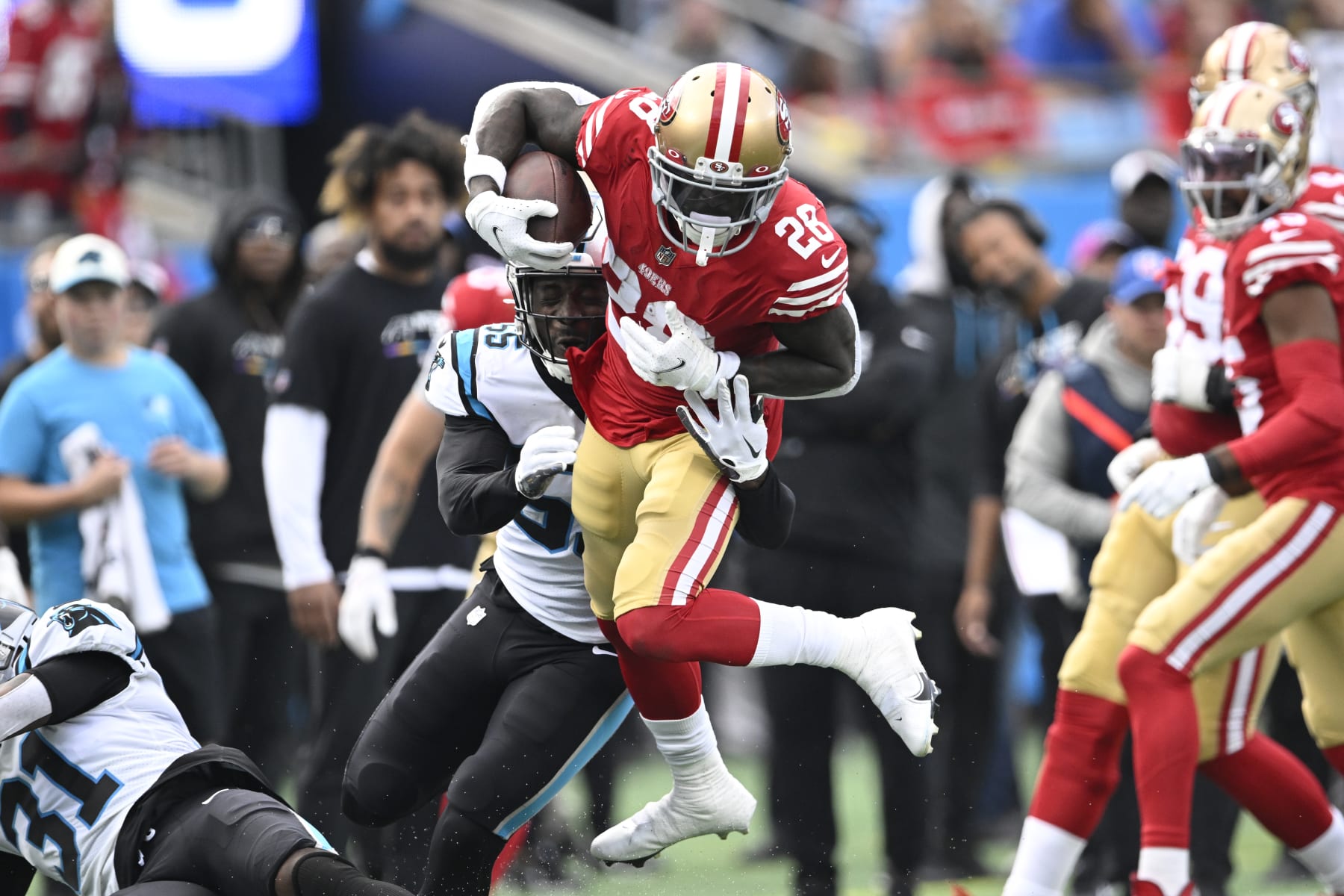 CHARLOTTE, NORTH CAROLINA - OCTOBER 09: Tevin Coleman #28 of the San Francisco 49ers is tackled by Cory Littleton #55 of the Carolina Panthers during the second quarter of the game at Bank of America Stadium on October 09, 2022 in Charlotte, North Carolina. (Photo by Eakin Howard/Getty Images)