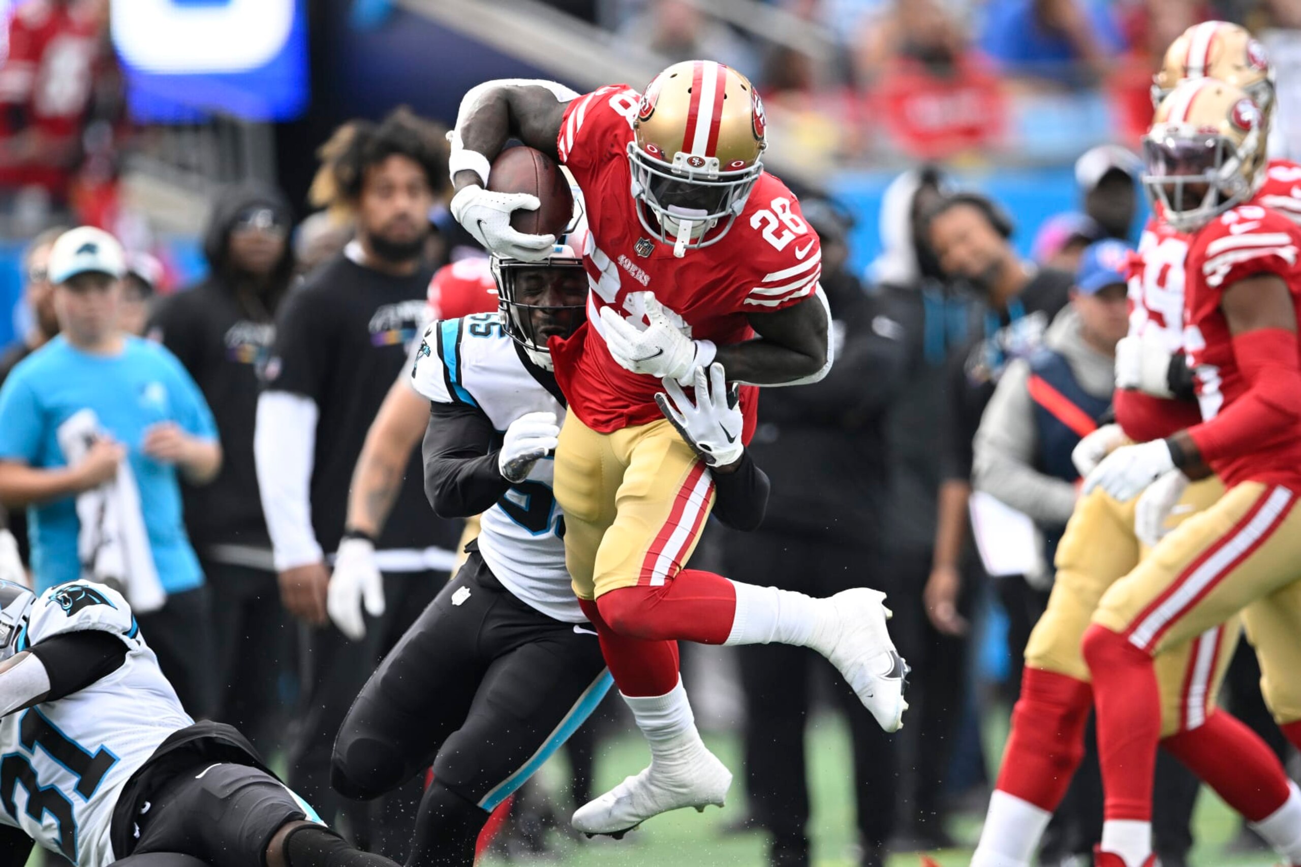 CHARLOTTE, NORTH CAROLINA - OCTOBER 09: Tevin Coleman #28 of the San Francisco 49ers is tackled by Cory Littleton #55 of the Carolina Panthers during the second quarter of the game at Bank of America Stadium on October 09, 2022 in Charlotte, North Carolina. (Photo by Eakin Howard/Getty Images)