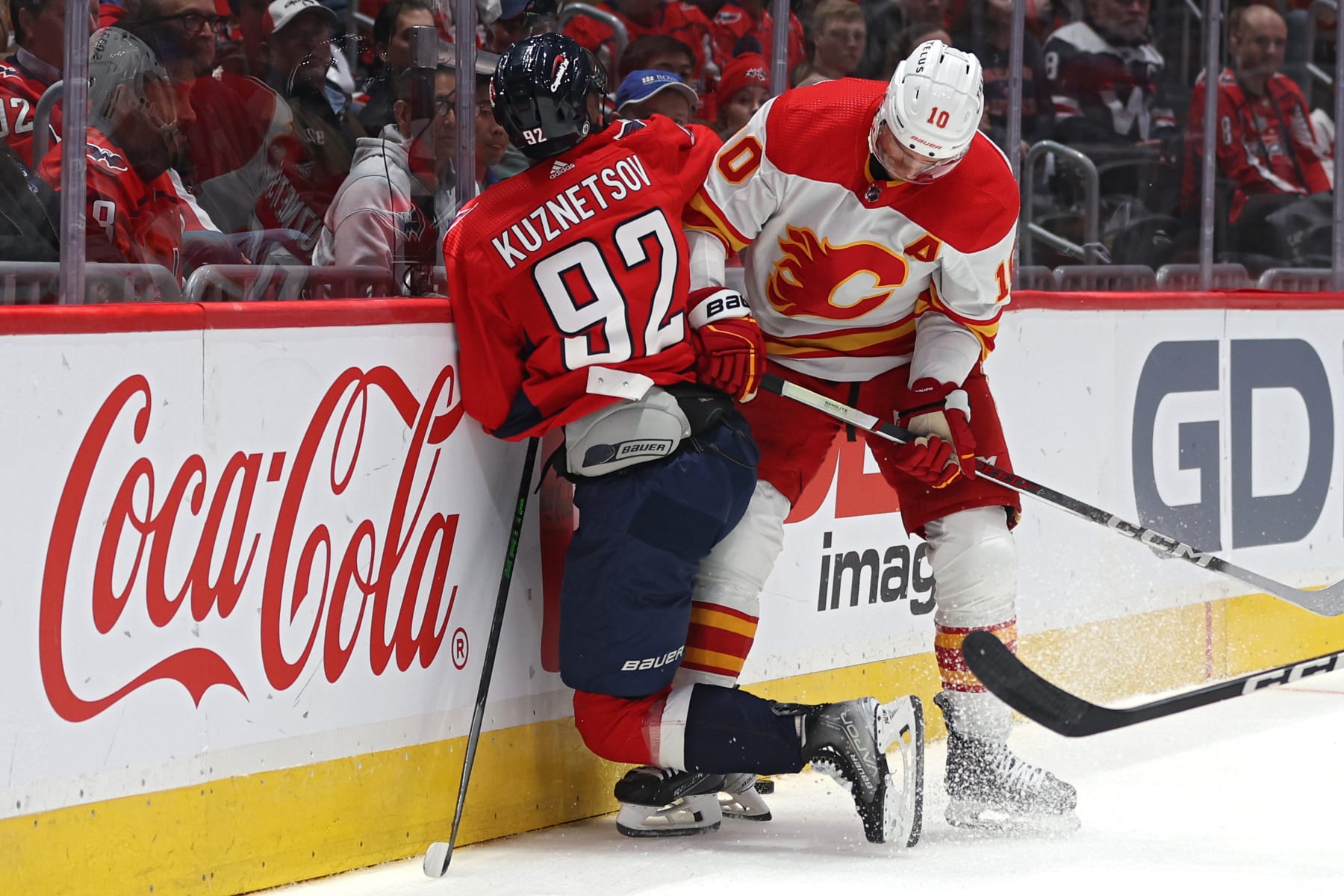 WASHINGTON, DC - OCTOBER 16: Jonathan Huberdeau #10 of the Calgary Flames checks Evgeny Kuznetsov #92 of the Washington Capitals during the first period at Capital One Arena on October 16, 2023 in Washington, DC. (Photo by Patrick Smith/Getty Images)