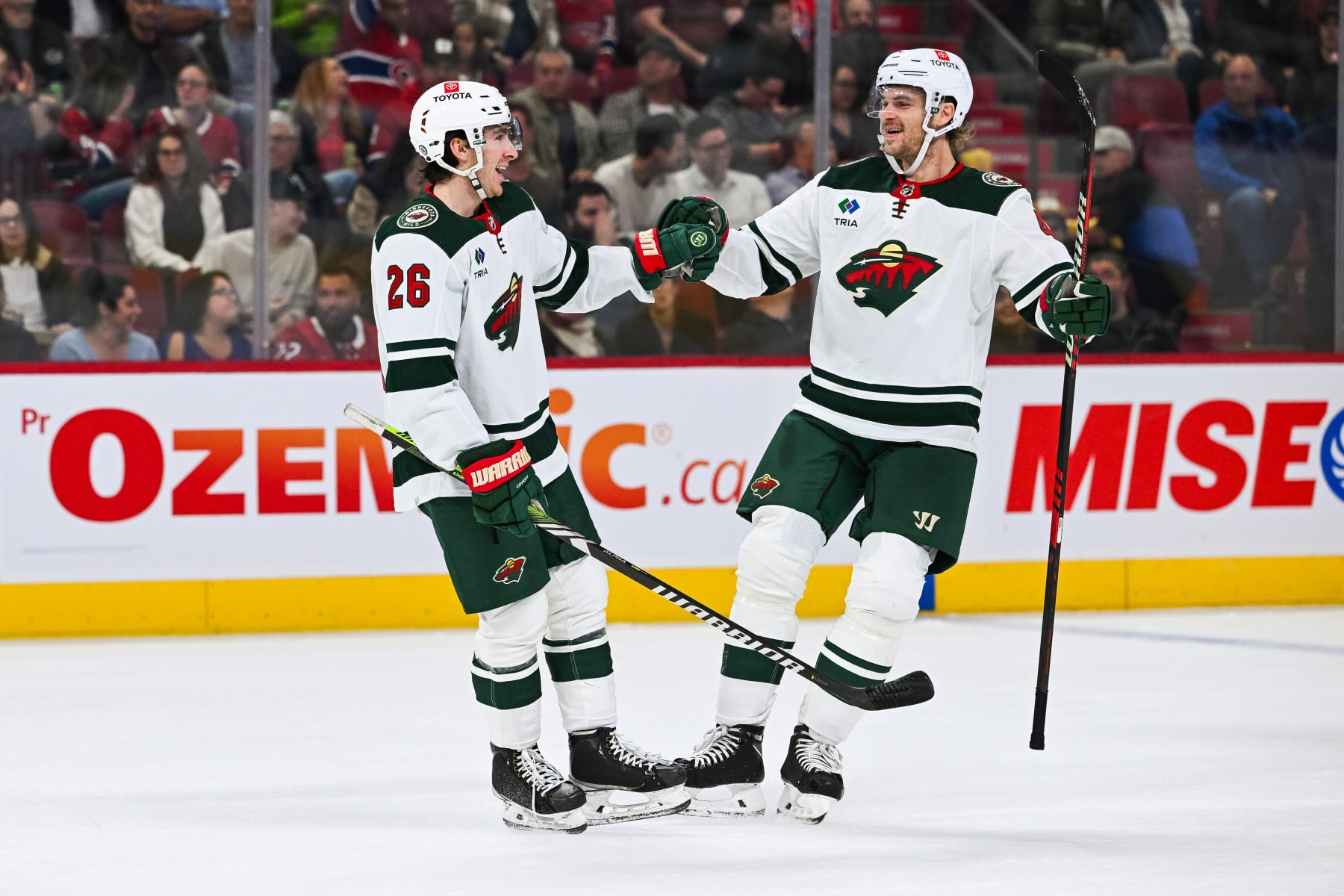 MONTREAL, QC - OCTOBER 17: Montreal Canadiens defenseman Johnathan Kovacevic (26) celebrates his goal with  Minnesota Wild defenseman Jon Merrill (4) during the Minnesota Wild versus the Montreal Canadiens game on October 17, 2023, at Bell Centre in Montreal, QC (Photo by David Kirouac/Icon Sportswire via Getty Images)
