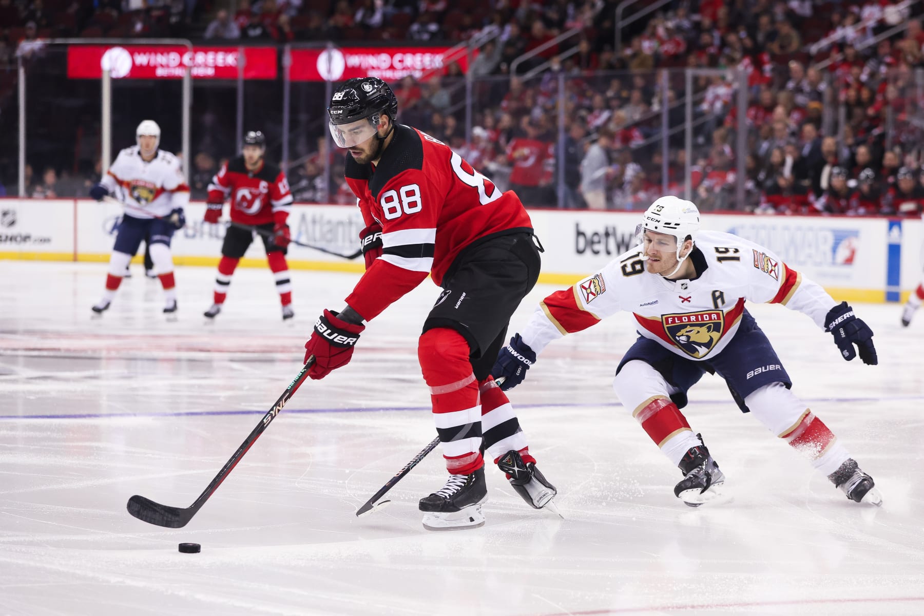 NEWARK, NJ - OCTOBER 16: New Jersey Devils defenseman Kevin Bahl (88) skates with the puck while being chased by Florida Panthers left wing Matthew Tkachuk (19) during a game between the Florida Panthers and New Jersey Devils on October 16, 2023 at Prudential Center in the Newark, New Jersey.(Photo by Andrew Mordzynski/Icon Sportswire via Getty Images)