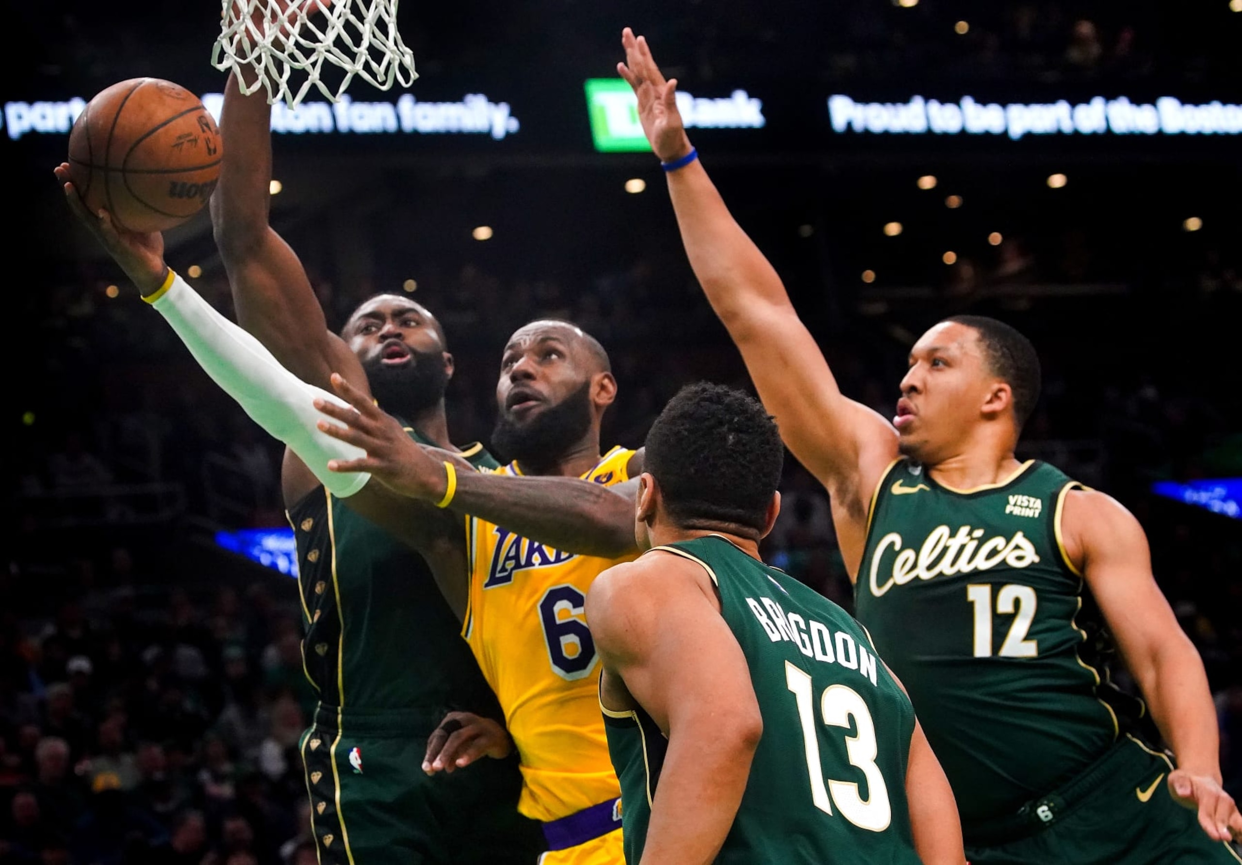Boston, MA - January 28: Los Angeles Lakers SF LeBron James slices through Boston Celtics SG Jaylen Brown, left, and PF Grant Williams, right, on his way to a lay-up in the first quarter. The Lakers lost to the Celtics, 125-121, in overtime. (Photo by Barry Chin/The Boston Globe via Getty Images)