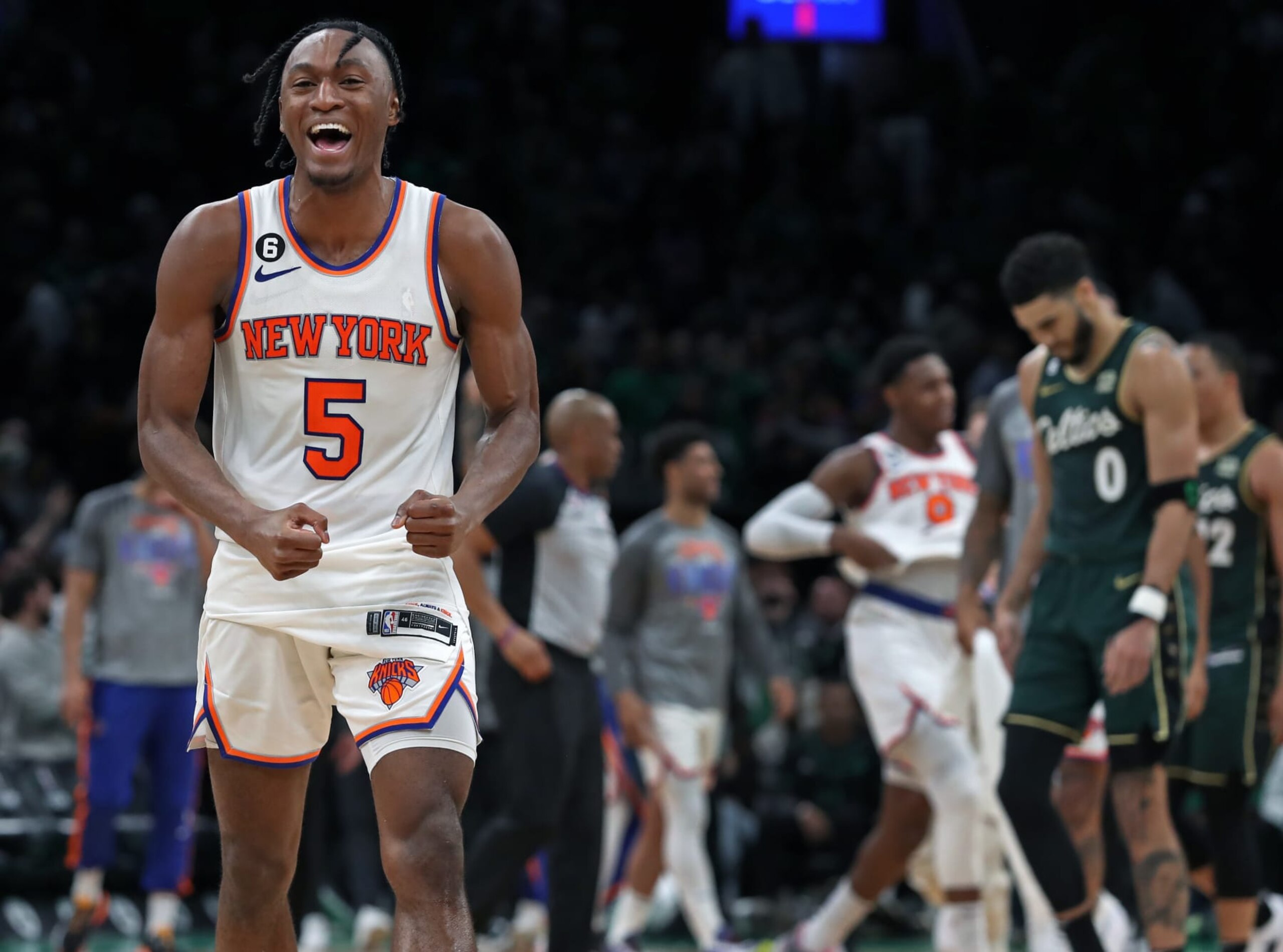 Boston, MA - March 5: New York Knicks SG Immanuel Quickley walks off the court smiling after his team defeated the Boston Celtics, 131-129, in double overtime. A dejected Jayson Tatum is in the background. (Photo by Jim Davis/The Boston Globe via Getty Images)