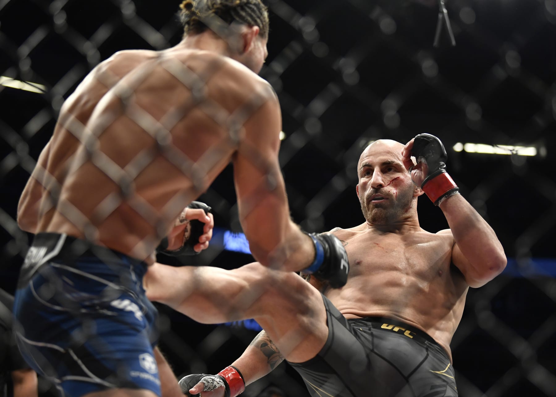 LAS VEGAS, NEVADA - SEPTEMBER 25: (R-L) Alexander Volkanovski of Australia kicks Brian Ortega in their UFC featherweight championship fight during the UFC 266 event on September 25, 2021 in Las Vegas, Nevada. (Photo by Chris Unger/Zuffa LLC)
