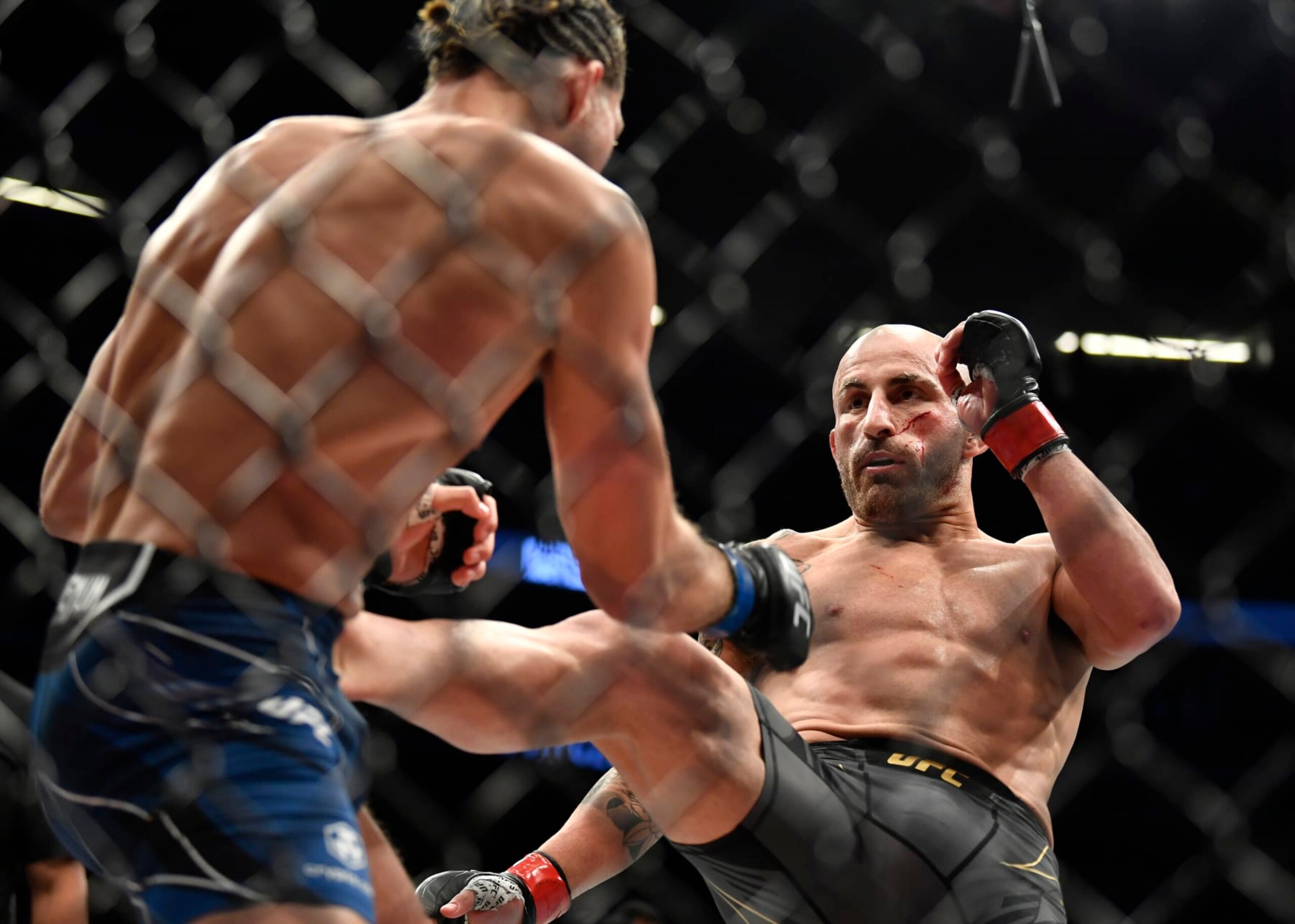 LAS VEGAS, NEVADA - SEPTEMBER 25: (R-L) Alexander Volkanovski of Australia kicks Brian Ortega in their UFC featherweight championship fight during the UFC 266 event on September 25, 2021 in Las Vegas, Nevada. (Photo by Chris Unger/Zuffa LLC)