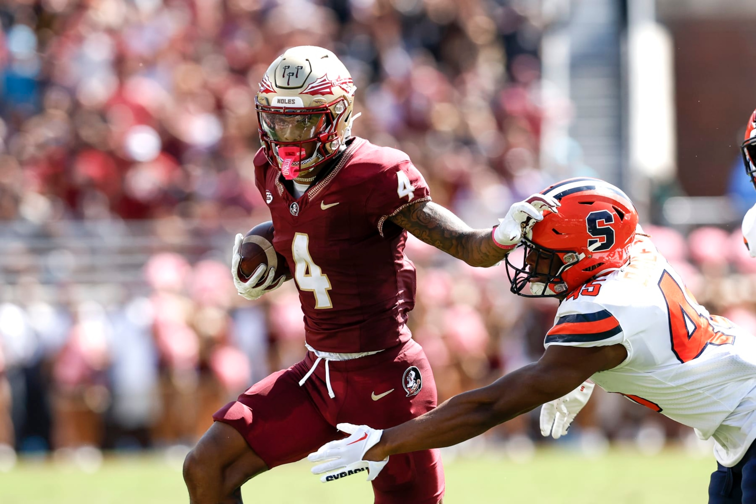 TALLAHASSEE, FL - OCTOBER 14: Wide Receiver Keon Coleman #4 of the Florida State Seminoles gives a stiff arm after a catch and run to Linebacker Kadin Bailey #45 of the Syracuse Orange during the game at Doak Campbell Stadium on Bobby Bowden Field on October 14, 2023 in Tallahassee, Florida. The 4th ranked Seminoles defeated the Orange 41 to 3. (Photo by Don Juan Moore/Getty Images)