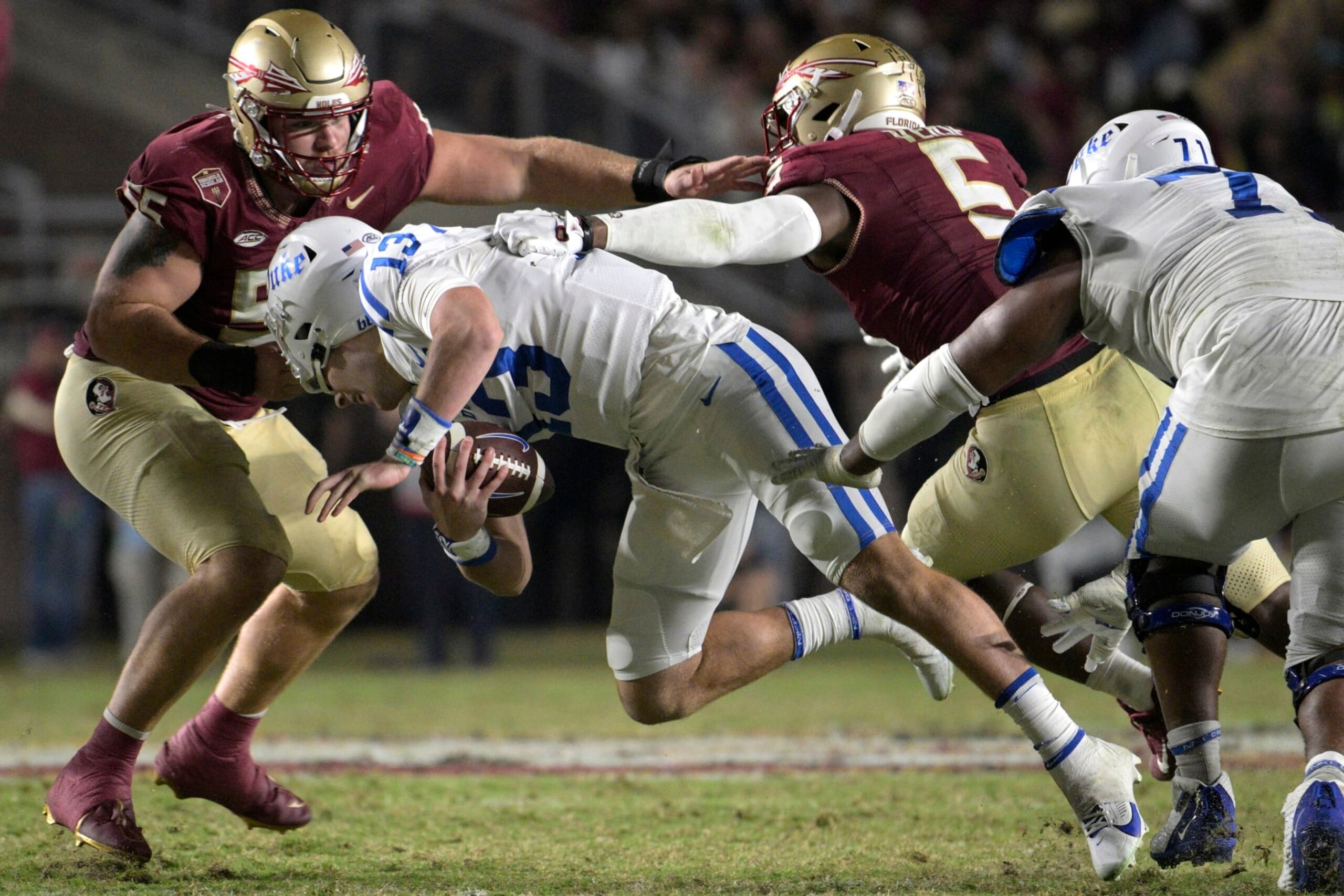 Duke quarterback Riley Leonard (13) is pulled down by his face mask by Florida State defensive lineman Braden Fiske (55) as defensive lineman Jared Verse (5) assists during the second half of an NCAA college football game, Saturday, Oct. 21, 2023, in Tallahassee, Fla. (AP Photo/Phelan M. Ebenhack)