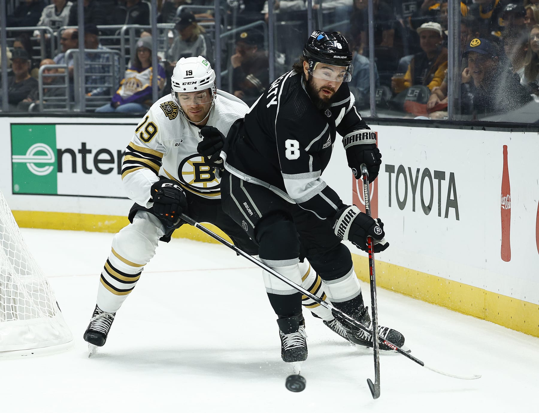 LOS ANGELES, CALIFORNIA - OCTOBER 21: Drew Doughty #8 of the Los Angeles Kings skates the puck against Johnny Beecher #19 of the Boston Bruins in the first period at Crypto.com Arena on October 21, 2023 in Los Angeles, California. (Photo by Ronald Martinez/Getty Images) LOS ANGELES, CALIFORNIA - OCTOBER 21: Drew Doughty #8 of the Los Angeles Kings skates the puck against Johnny Beecher #19 of the Boston Bruins in the first period at Crypto.com Arena on October 21, 2023 in Los Angeles, California. (Photo by Ronald Martinez/Getty Images)