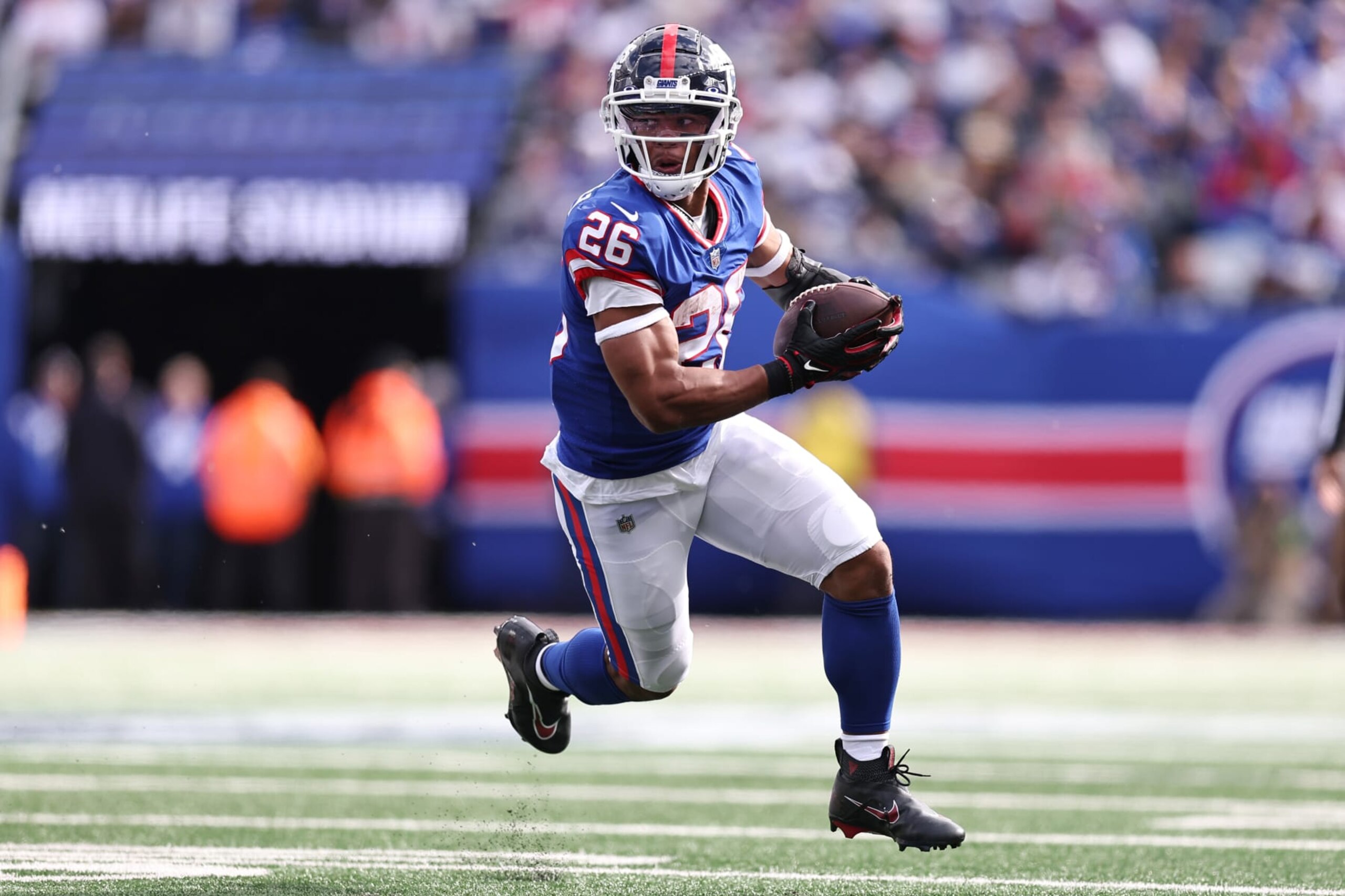 EAST RUTHERFORD, NEW JERSEY - OCTOBER 22: Saquon Barkley #26 of the New York Giants runs with the ball to score a touchdown in the second quarter of the game against the Washington Commanders at MetLife Stadium on October 22, 2023 in East Rutherford, New Jersey. (Photo by Dustin Satloff/Getty Images)