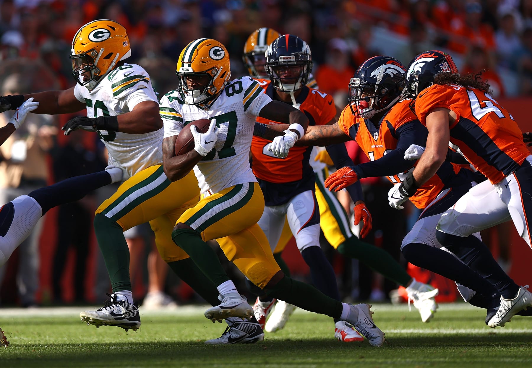 DENVER, COLORADO - OCTOBER 22: Romeo Doubs #87 of the Green Bay Packers carries the ball in the second quarter of the game against the Denver Broncos at Empower Field At Mile High on October 22, 2023 in Denver, Colorado. (Photo by Jamie Schwaberow/Getty Images)