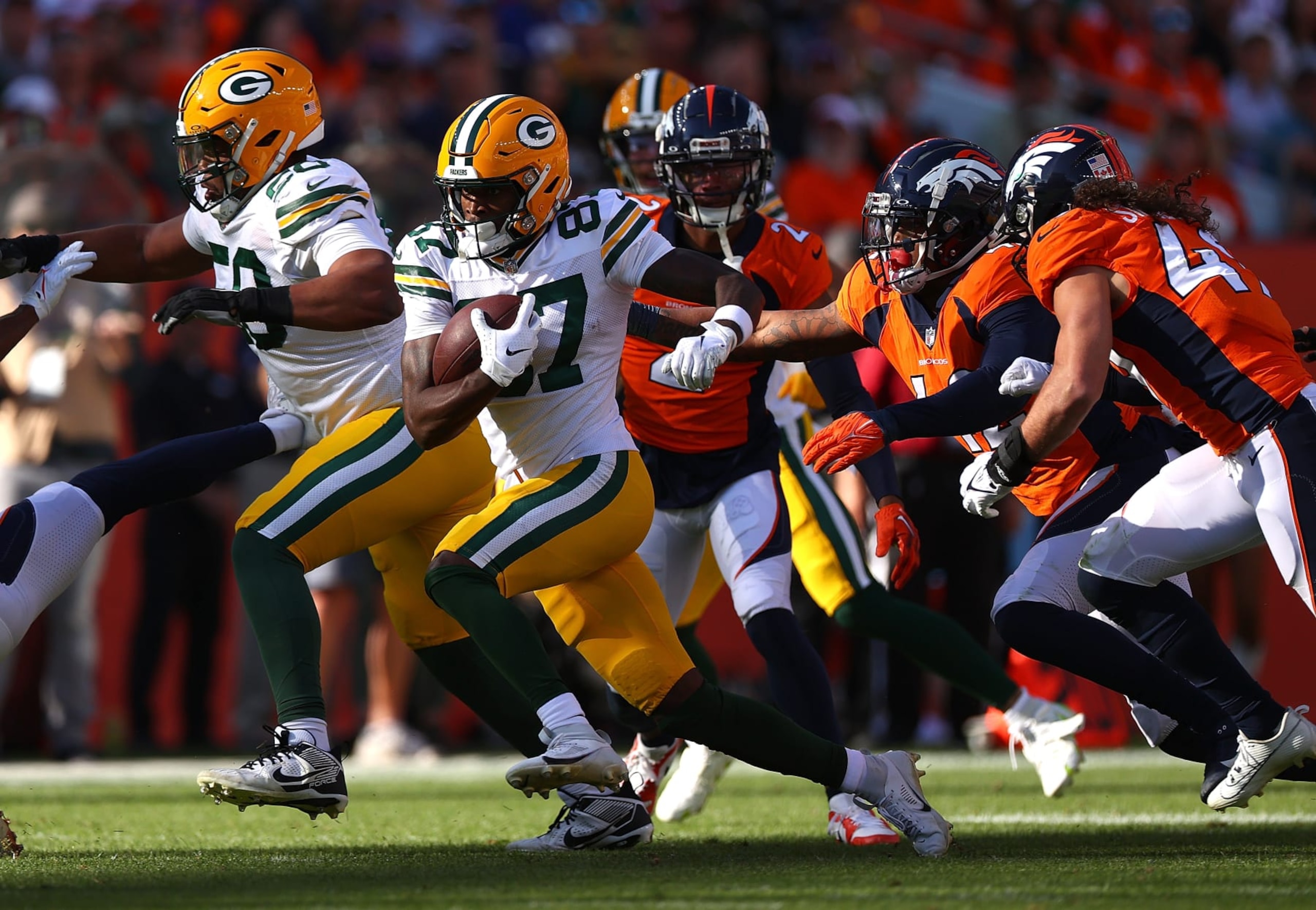 DENVER, COLORADO - OCTOBER 22: Romeo Doubs #87 of the Green Bay Packers carries the ball in the second quarter of the game against the Denver Broncos at Empower Field At Mile High on October 22, 2023 in Denver, Colorado. (Photo by Jamie Schwaberow/Getty Images)
