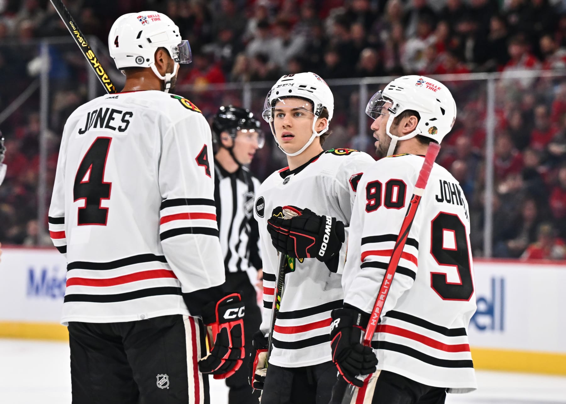 MONTREAL, CANADA - OCTOBER 14:  Connor Bedard #98 of the Chicago Blackhawks has a discussion with teammates Seth Jones #4 and Tyler Johnson #90 during the first period against the Montreal Canadiens at the Bell Centre on October 14, 2023 in Montreal, Quebec, Canada.  The Montreal Canadiens defeated the Chicago Blackhawks 3-2.  (Photo by Minas Panagiotakis/Getty Images)