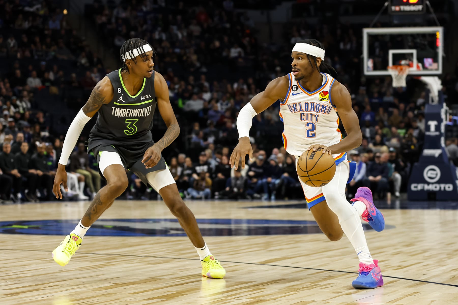 MINNEAPOLIS, MN - DECEMBER 03: Shai Gilgeous-Alexander #2 of the Oklahoma City Thunder dribbles the ball while Jaden McDaniels #3 of the Minnesota Timberwolves defends in the first quarter of the game at Target Center on December 3, 2022 in Minneapolis, Minnesota. The Thunder defeated the Timberwolves 135-128. NOTE TO USER: User expressly acknowledges and agrees that, by downloading and or using this Photograph, user is consenting to the terms and conditions of the Getty Images License Agreement. (Photo by David Berding/Getty Images)