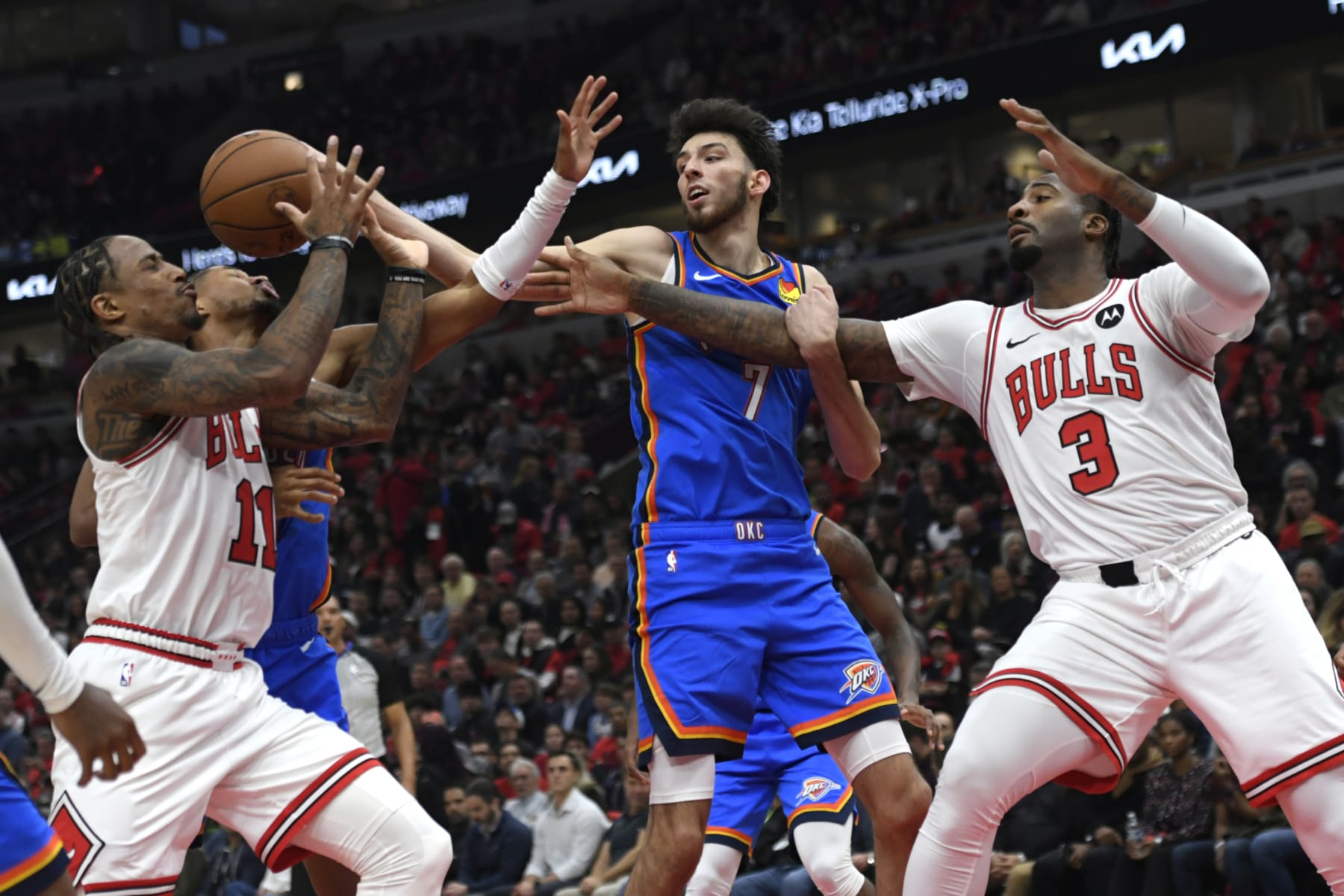 Chicago Bulls' DeMar DeRozan (11) and Andre Drummond (3) battle Oklahoma City Thunder's Chet Holmgren (7) and Isaiah Joe, second from left, for a rebound during the first half of an NBA basketball game Wednesday, Oct. 25, 2023, in Chicago. (AP Photo/Paul Beaty)
