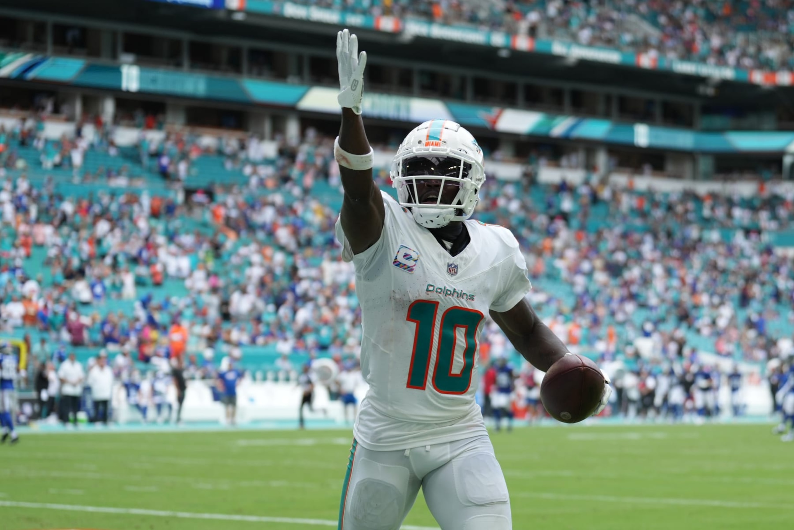 MIAMI GARDENS, FL - OCTOBER 08: Miami Dolphins wide receiver Tyreek Hill (10) looks for someone specific to give the touchdown ball to following his long touchdown catch and run in the second half during the game between the New York Giants and the Miami Dolphins on Sunday, October 8, 2023 at Hard Rock Stadium, Miami Gardens, Fla. (Photo by Peter Joneleit/Icon Sportswire via Getty Images)