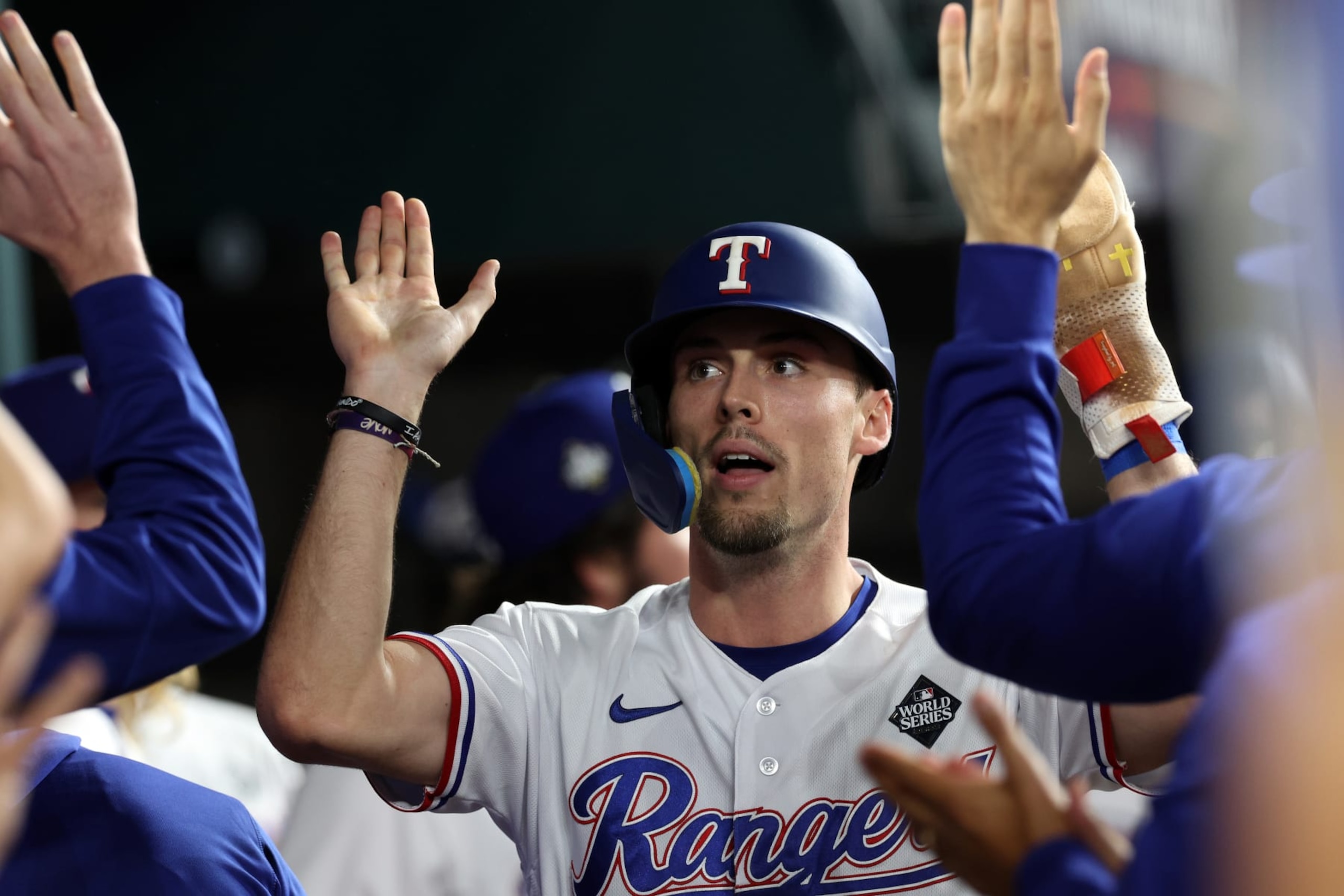 ARLINGTON, TEXAS - OCTOBER 27: Evan Carter #32 of the Texas Rangers celebrates with teammates after scoring a run in the first inning against the Arizona Diamondbacks during Game One of the World Series at Globe Life Field on October 27, 2023 in Arlington, Texas. (Photo by Jamie Squire/Getty Images)