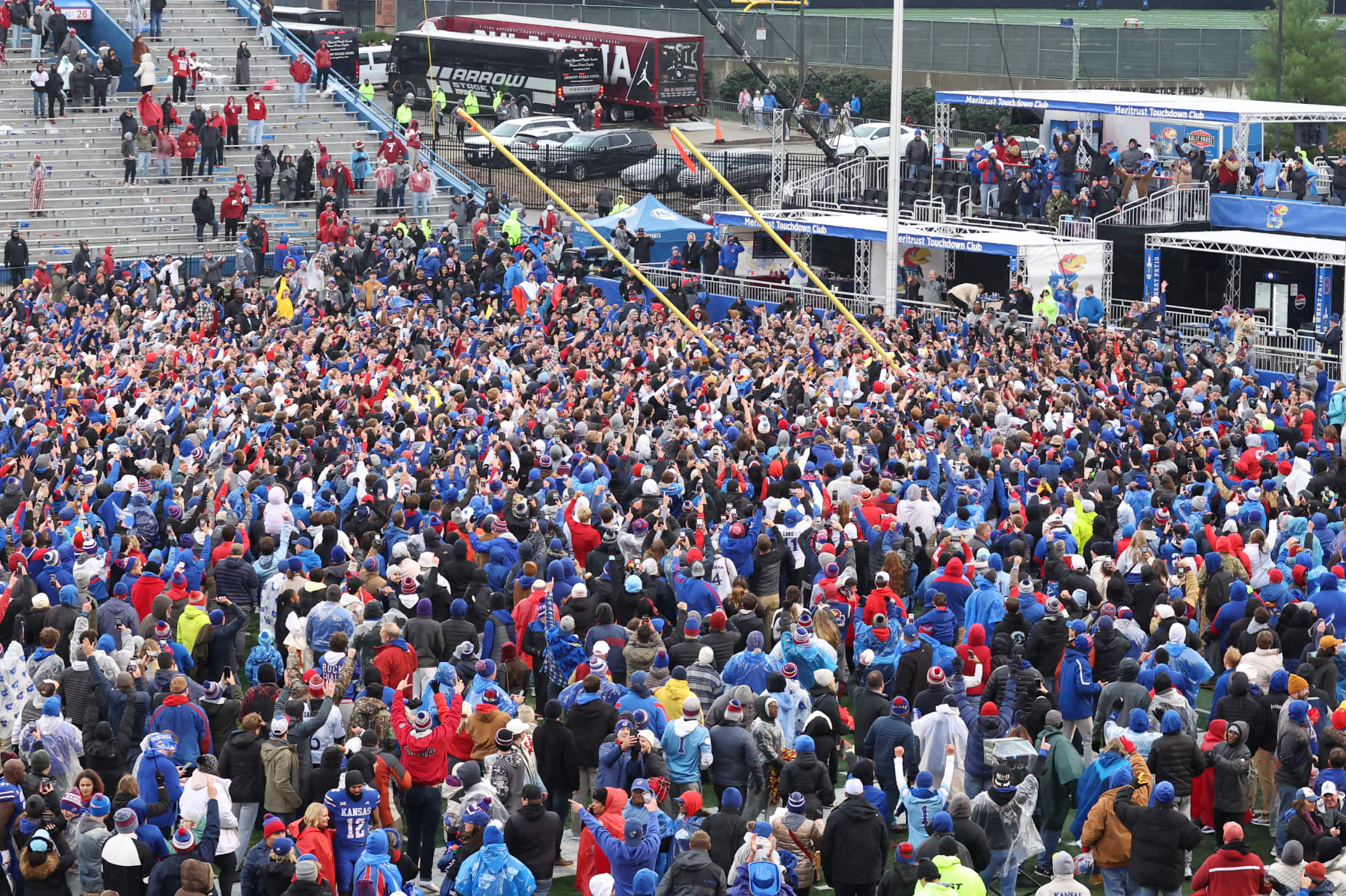 LAWRENCE, KS - OCTOBER 28: Kansas Jayhawks fans climb the goal posts to take them down after defeating the Oklahoma Sooners on Oct 28, 2023 at Memorial Stadium in Lawrence, KS.  (Photo by Scott Winters/Icon Sportswire via Getty Images)