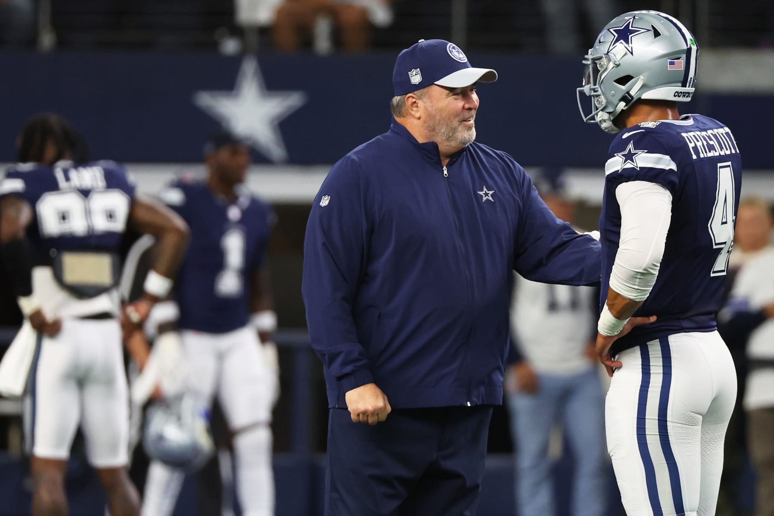 Cowboys coach Mike McCarthy talks with QB Dak Prescott
