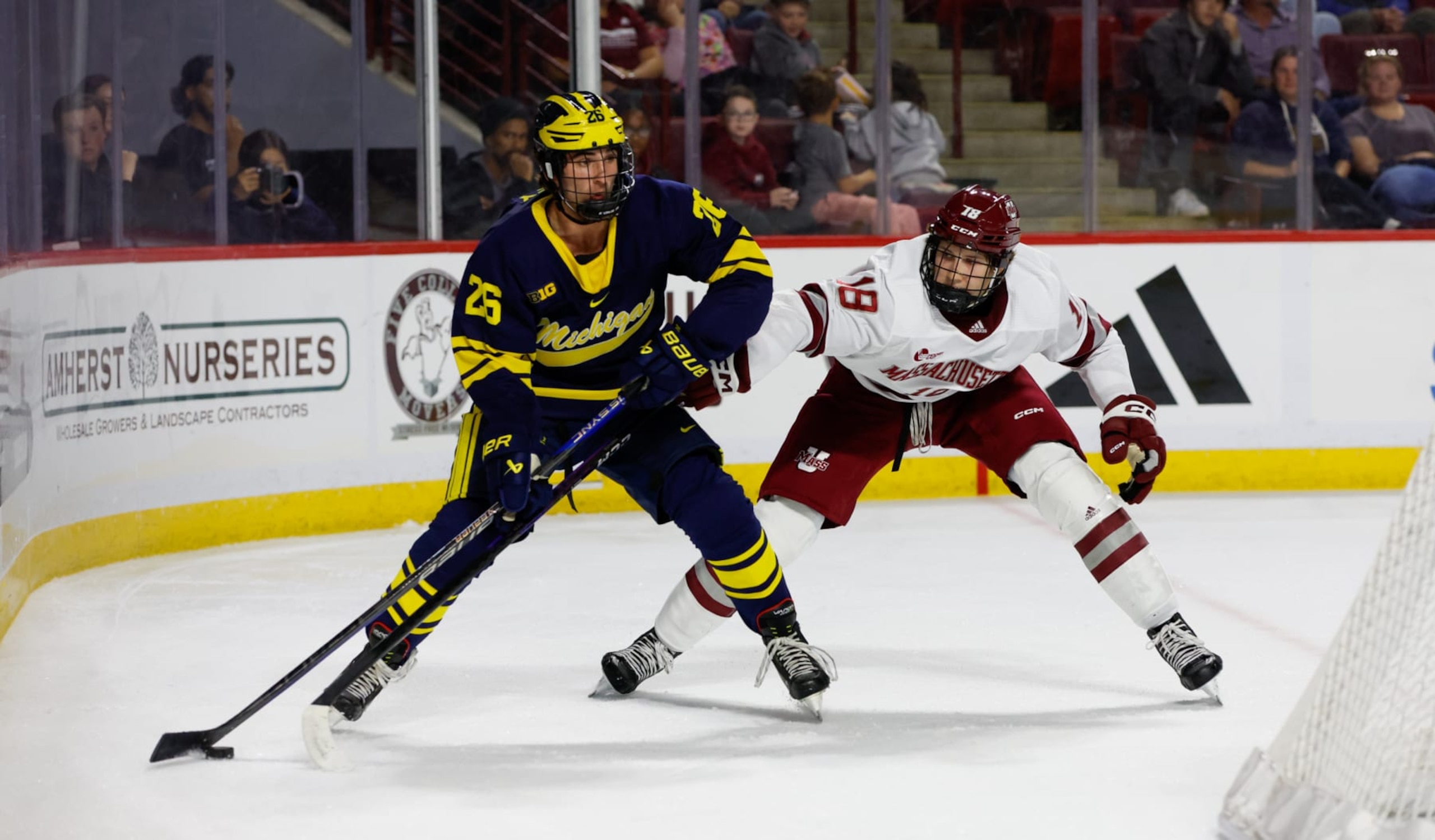 AMHERST, MASSACHUSETTS - OCTOBER 13: Seamus Casey #26 of the Michigan Wolverines is chased by Taylor Makar #18 of the Massachusetts Minutemen during the first period during NCAA  men's hockey at the Mullins Center on October 13, 2023 in Amherst, Massachusetts. The Wolverines won 7-2. (Photo by Richard T Gagnon/Getty Images)