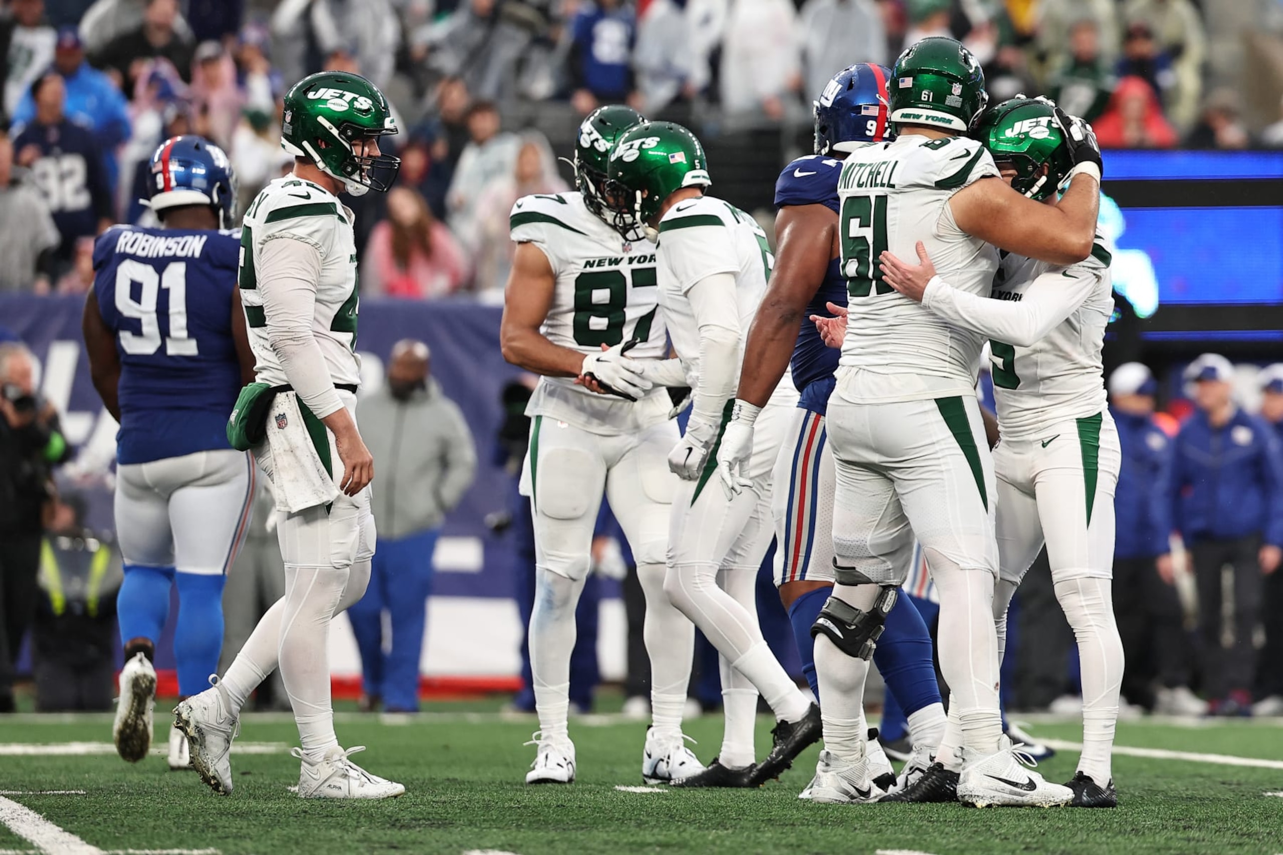 EAST RUTHERFORD, NEW JERSEY - OCTOBER 29: Max Mitchell #61 of the New York Jets hugs Greg Zuerlein #9 of the New York Jets after Zuerlein's game winning field goal in overtime against the New York Giants at MetLife Stadium on October 29, 2023 in East Rutherford, New Jersey. (Photo by Dustin Satloff/Getty Images)
