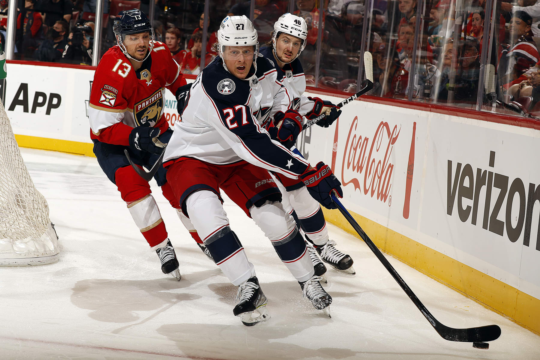 SUNRISE, FL - FEBRUARY 24: Adam Boqvist #27 of the Columbus Blue Jackets attempts to gather the puck along the boards against Sam Reinhart #13 of the Florida Panthers at the FLA Live Arena on February 24, 2022 in Sunrise, Florida. (Photo by Eliot J. Schechter/NHLI via Getty Images)