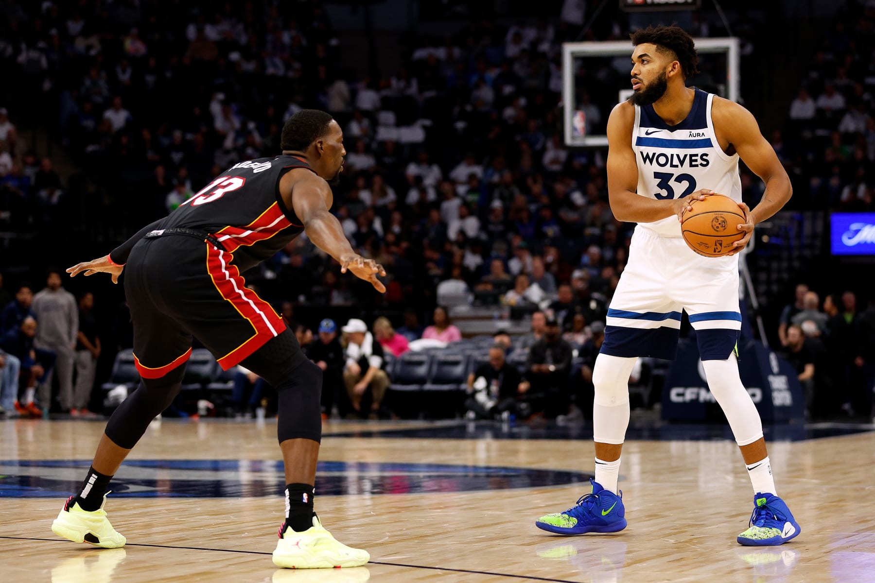 MINNEAPOLIS, MINNESOTA - OCTOBER 28: Karl-Anthony Towns #32 of the Minnesota Timberwolves looks to pass while Bam Adebayo #13 of the Miami Heat defends in the third quarter at Target Center on October 28, 2023 in Minneapolis, Minnesota. The Timberwolves defeated the Heat 106-90. NOTE TO USER: User expressly acknowledges and agrees that, by downloading and or using this photograph, User is consenting to the terms and conditions of the Getty Images License Agreement. (Photo by David Berding/Getty Images)