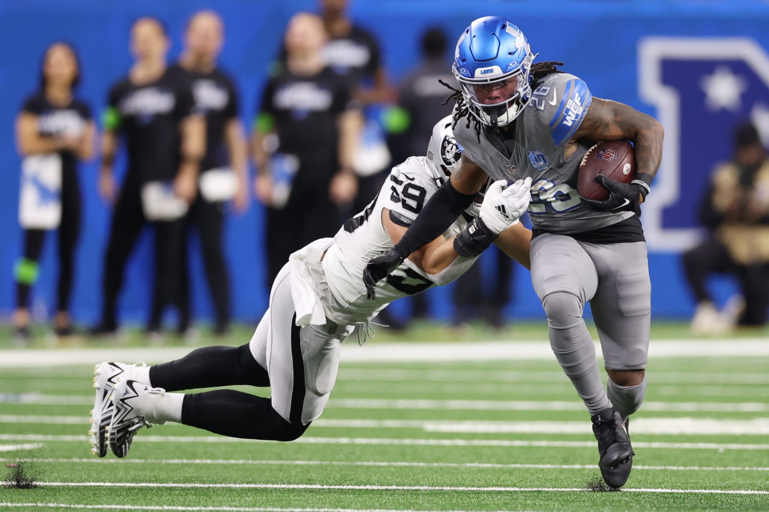 DETROIT, MICHIGAN - OCTOBER 30: Jahmyr Gibbs #26 of the Detroit Lions tries to avoid the tackle of Luke Masterson #59 of the Las Vegas Raiders in the first quarter at Ford Field on October 30, 2023 in Detroit, Michigan. (Photo by Gregory Shamus/Getty Images)