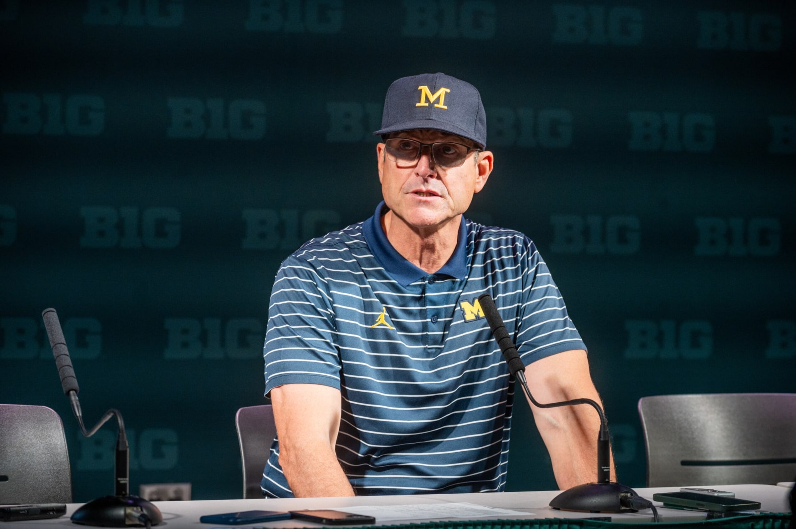 EAST LANSING, MICHIGAN - OCTOBER 21: Head coach Jim Harbaugh of the Michigan Wolverines speaks to media during the post game press conference after a college football game against the Michigan State Spartans at Spartan Stadium on October 21, 2023 in East Lansing, Michigan. The Michigan Wolverines won the game 49-0. (Photo by Aaron J. Thornton/Getty Images)