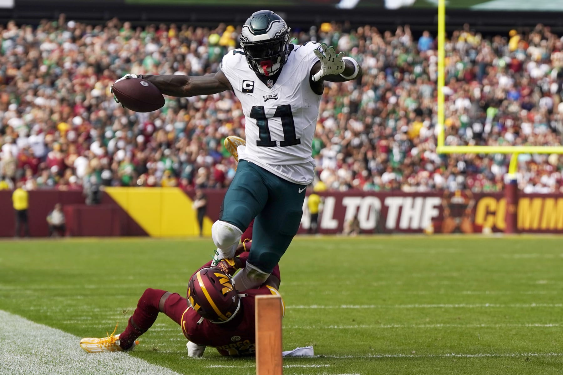 LANDOVER, MARYLAND - OCTOBER 29: A.J. Brown #11 of the Philadelphia Eagles runs as he is tackled by Emmanuel Forbes #13 of the Washington Commanders during the second quarter at FedExField on October 29, 2023 in Landover, Maryland. (Photo by Jess Rapfogel/Getty Images)