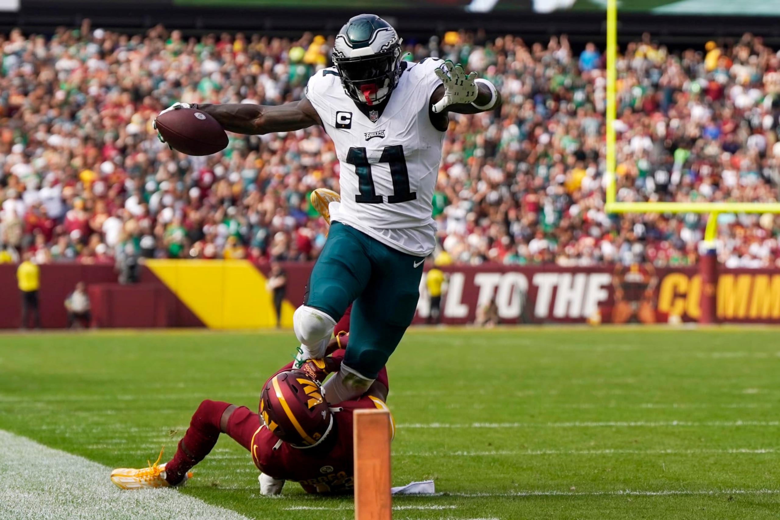 LANDOVER, MARYLAND - OCTOBER 29: A.J. Brown #11 of the Philadelphia Eagles runs as he is tackled by Emmanuel Forbes #13 of the Washington Commanders during the second quarter at FedExField on October 29, 2023 in Landover, Maryland. (Photo by Jess Rapfogel/Getty Images)