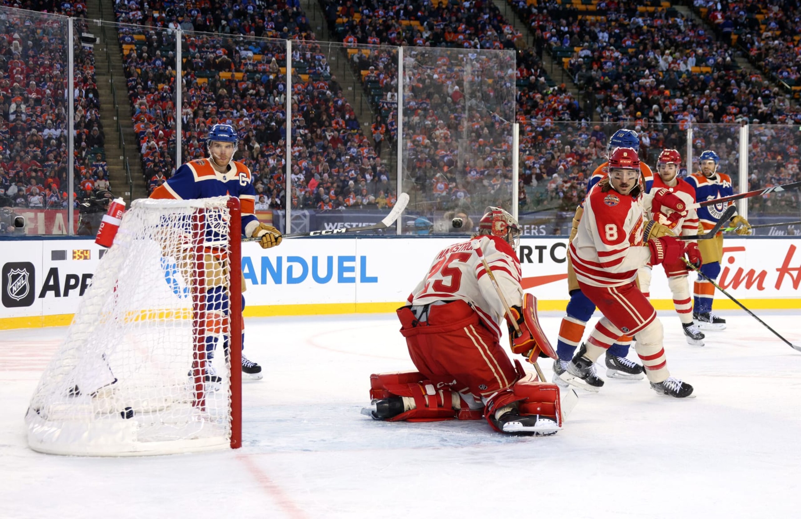 EDMONTON, ALBERTA - OCTOBER 29: Goaltender Jacob Markstrom #25 of the Calgary Flames can't make the save on a shot from the point for a goal by Evan Bouchard #2 of the Edmonton Oilers (not in photo) as Connor McDavid #97 of the Edmonton Oilers and Chris Tanev #8 of the Calgary Flames look on during the first period of the 2023 Tim Hortons NHL Heritage Classic between the Calgary Flames and the Edmonton Oilers at Commonwealth Stadium on October 29, 2023 in Edmonton, Alberta. (Photo by Dave Sandford/NHLI via Getty Images) EDMONTON, ALBERTA - OCTOBER 29: Goaltender Jacob Markstrom #25 of the Calgary Flames can't make the save on a shot from the point for a goal by Evan Bouchard #2 of the Edmonton Oilers (not in photo) as Connor McDavid #97 of the Edmonton Oilers and Chris Tanev #8 of the Calgary Flames look on during the first period of the 2023 Tim Hortons NHL Heritage Classic between the Calgary Flames and the Edmonton Oilers at Commonwealth Stadium on October 29, 2023 in Edmonton, Alberta. (Photo by Dave Sandford/NHLI via Getty Images)