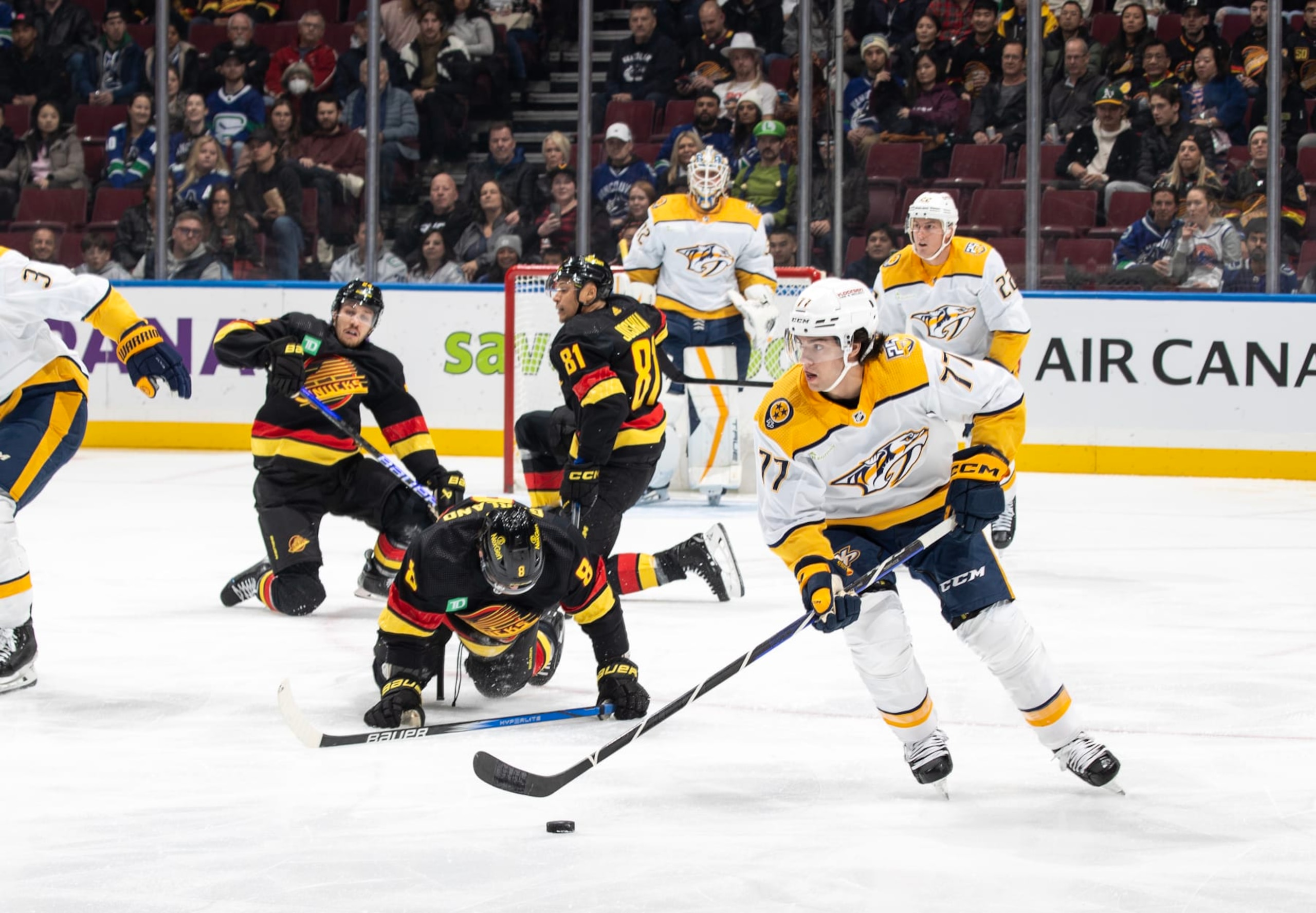VANCOUVER, CANADA - OCTOBER 31: Luke Evangelista #77 of the Nashville Predators skates by scrambled Vancouver Canucks during the first period of their NHL game at Rogers Arena October 31, 2023 in Vancouver, British Columbia, Canada. (Photo by Jeff Vinnick/NHLI via Getty Images) VANCOUVER, CANADA - OCTOBER 31: Luke Evangelista #77 of the Nashville Predators skates by scrambled Vancouver Canucks during the first period of their NHL game at Rogers Arena October 31, 2023 in Vancouver, British Columbia, Canada. (Photo by Jeff Vinnick/NHLI via Getty Images)