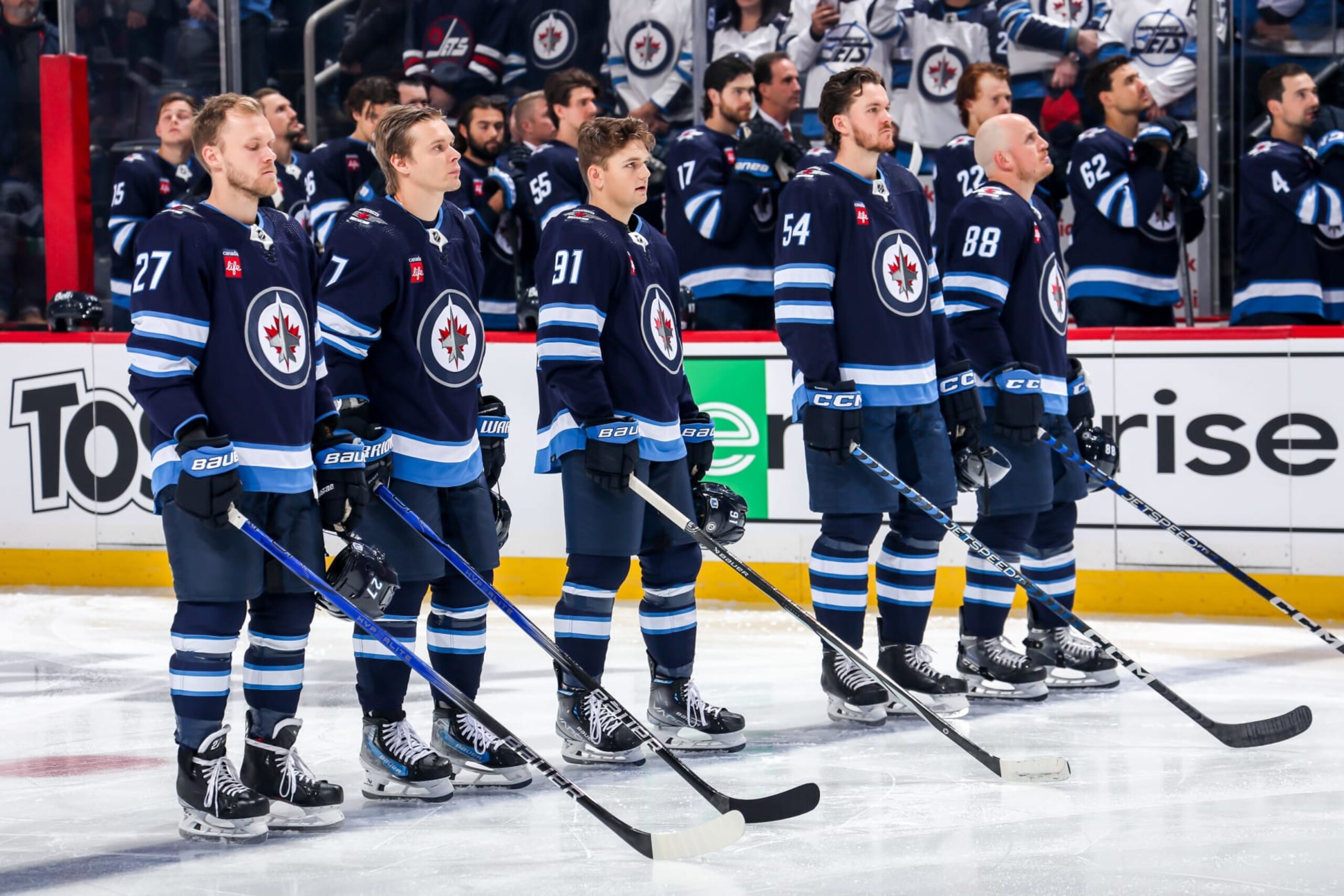 WINNIPEG, CANADA - OCTOBER 30: Nikolaj Ehlers #27, Vladislav Namestnikov #7, Cole Perfetti #91, Dylan Samberg #54 and Nate Schmidt #88 of the Winnipeg Jets stand on the ice during the singing of the National anthems prior to puck drop against the New York Rangers at the Canada Life Centre on October 30, 2023 in Winnipeg, Manitoba, Canada. (Photo by Darcy Finley/NHLI via Getty Images) WINNIPEG, CANADA - OCTOBER 30: Nikolaj Ehlers #27, Vladislav Namestnikov #7, Cole Perfetti #91, Dylan Samberg #54 and Nate Schmidt #88 of the Winnipeg Jets stand on the ice during the singing of the National anthems prior to puck drop against the New York Rangers at the Canada Life Centre on October 30, 2023 in Winnipeg, Manitoba, Canada. (Photo by Darcy Finley/NHLI via Getty Images)