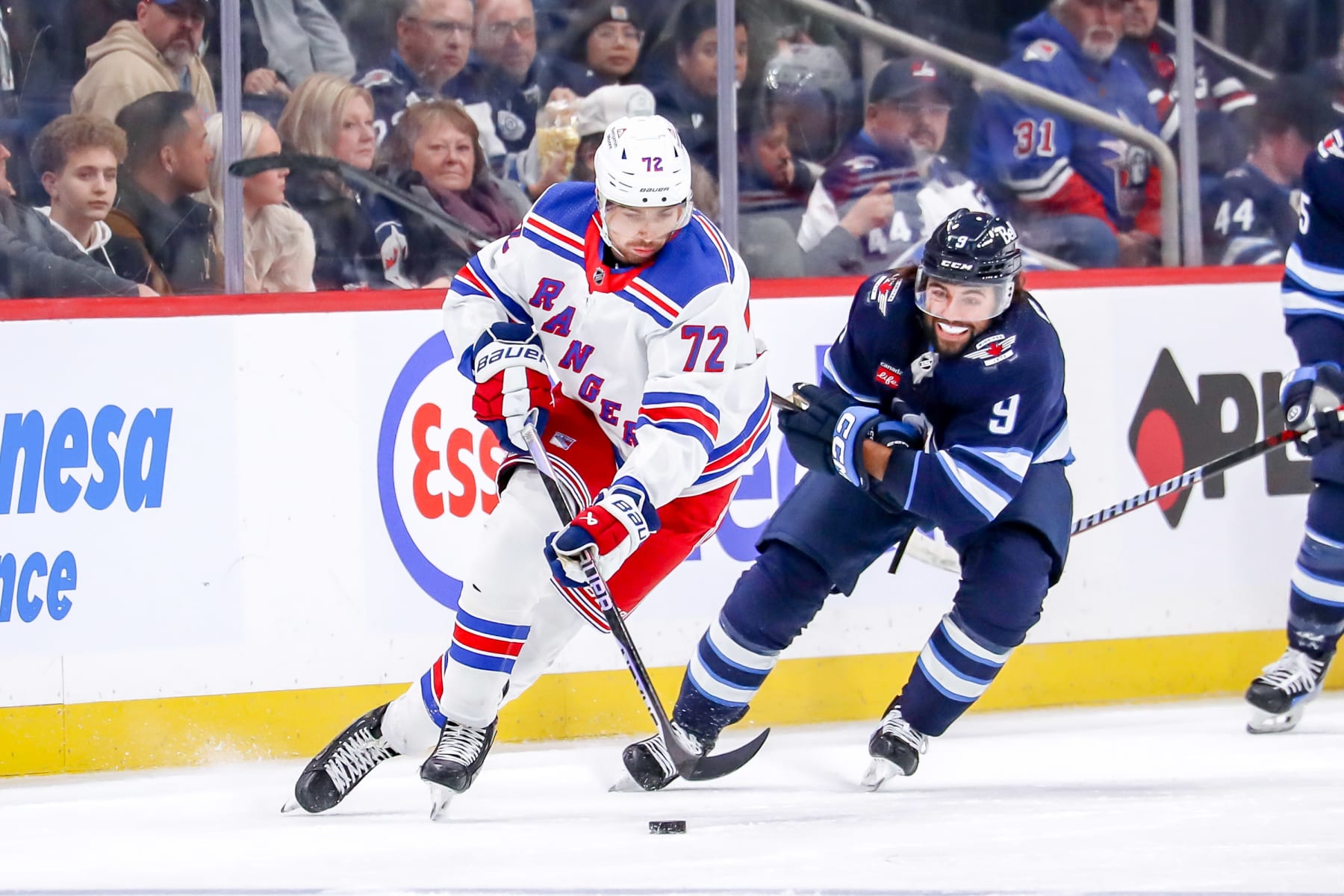 WINNIPEG, CANADA - OCTOBER 30: Filip Chytil #72 of the New York Rangers plays the puck down the ice as Alex Iafallo #9 of the Winnipeg Jets gives chase during second period action at the Canada Life Centre on October 30, 2023 in Winnipeg, Manitoba, Canada. (Photo by Darcy Finley/NHLI via Getty Images)