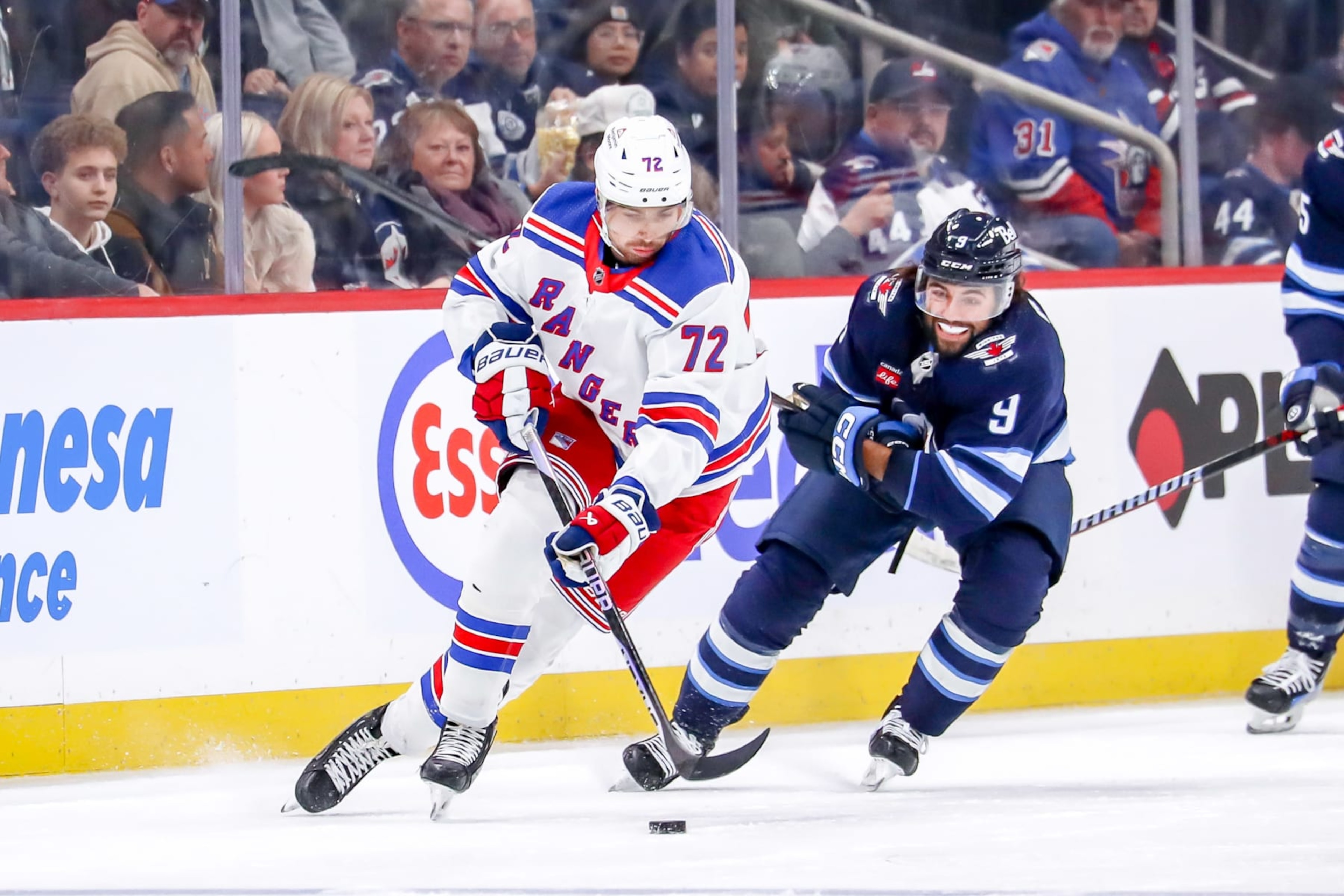 WINNIPEG, CANADA - OCTOBER 30: Filip Chytil #72 of the New York Rangers plays the puck down the ice as Alex Iafallo #9 of the Winnipeg Jets gives chase during second period action at the Canada Life Centre on October 30, 2023 in Winnipeg, Manitoba, Canada. (Photo by Darcy Finley/NHLI via Getty Images)
