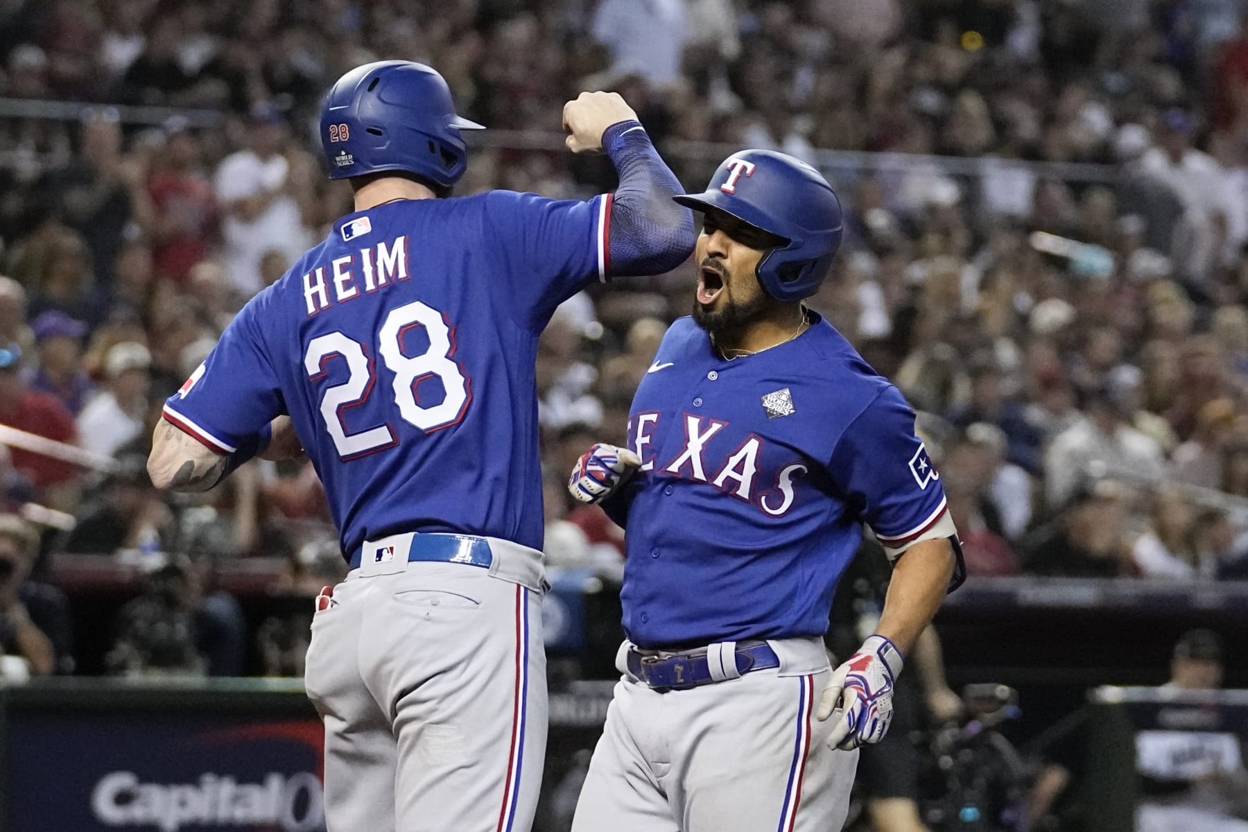 Texas Rangers' Marcus Semien celebrates his two-run home run with Jonah Heim against the Arizona Diamondbacks during the ninth inning in Game 5 of the baseball World Series Wednesday, Nov. 1, 2023, in Phoenix. (AP Photo/Brynn Anderson)
