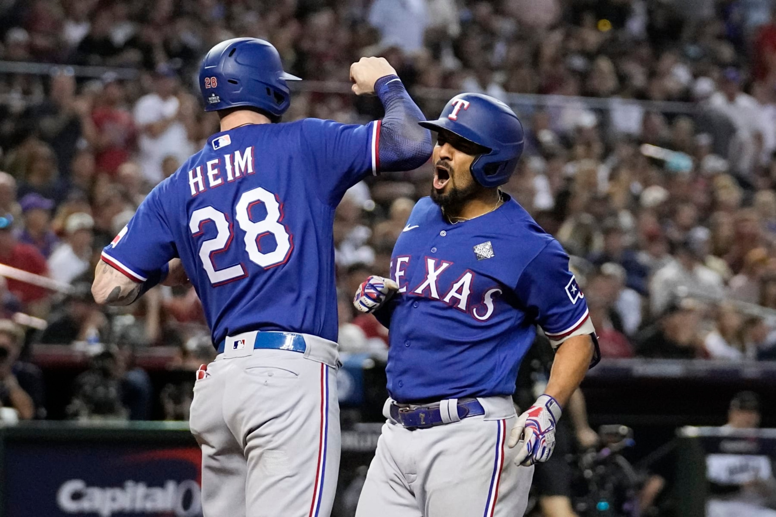 Texas Rangers' Marcus Semien celebrates his two-run home run with Jonah Heim against the Arizona Diamondbacks during the ninth inning in Game 5 of the baseball World Series Wednesday, Nov. 1, 2023, in Phoenix. (AP Photo/Brynn Anderson)