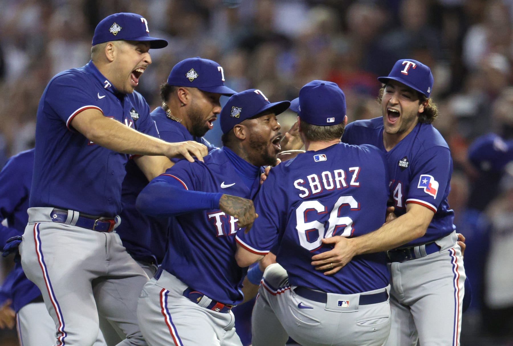 PHOENIX, ARIZONA - NOVEMBER 01: Josh Sborz #66 of the Texas Rangers celebrates with teammates Aroldis Chapman #45, Josh Smith #47 and Nathaniel Lowe #30 after defeating the Arizona Diamondbacks 5-0 in Game Five of the World Series at Chase Field on November 01, 2023 in Phoenix, Arizona. (Photo by Harry How/Getty Images)