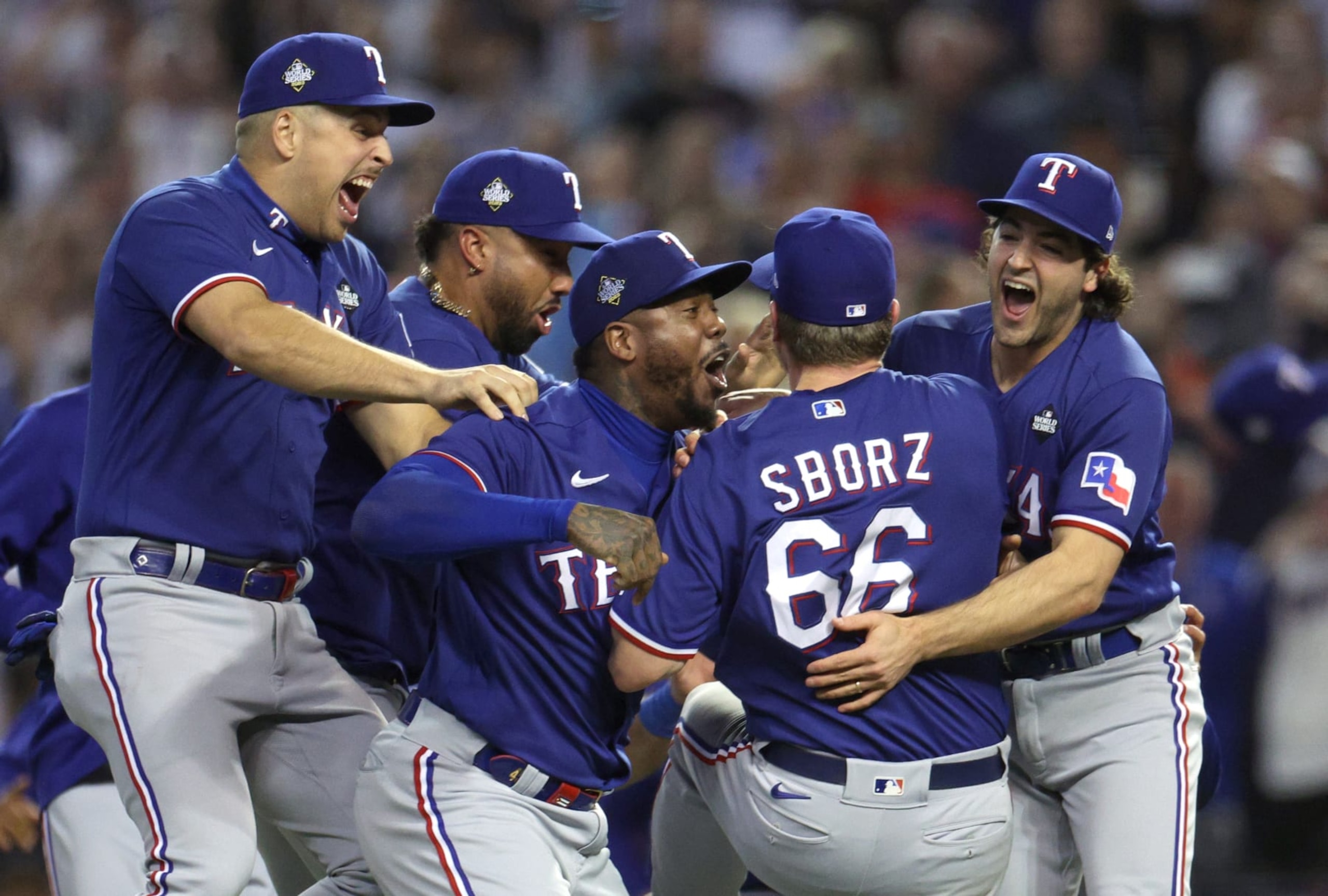 PHOENIX, ARIZONA - NOVEMBER 01: Josh Sborz #66 of the Texas Rangers celebrates with teammates Aroldis Chapman #45, Josh Smith #47 and Nathaniel Lowe #30 after defeating the Arizona Diamondbacks 5-0 in Game Five of the World Series at Chase Field on November 01, 2023 in Phoenix, Arizona. (Photo by Harry How/Getty Images)