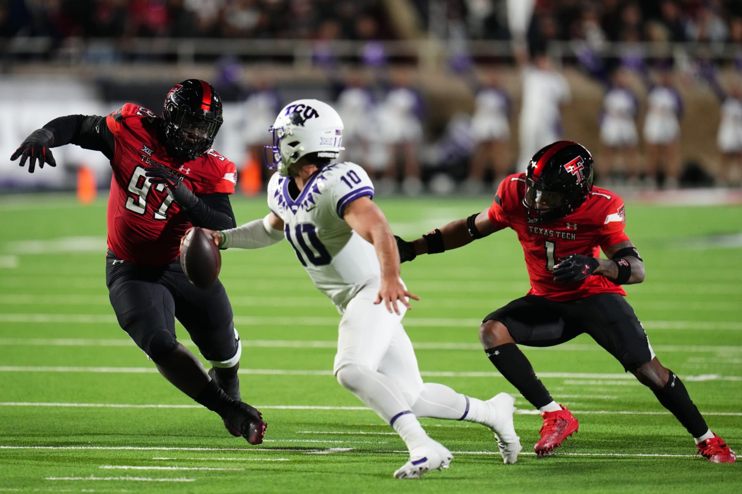 LUBBOCK, TEXAS - NOVEMBER 02: Josh Hoover #10 of the TCU Horned Frogs evades the pursuit of Tony Bradford Jr. #97 and Dadrion Taylor-Demerson #1 of the Texas Tech Red Raiders during the third quarter of at Jones AT&T Stadium on November 02, 2023 in Lubbock, Texas. (Photo by Josh Hedges/Getty Images)