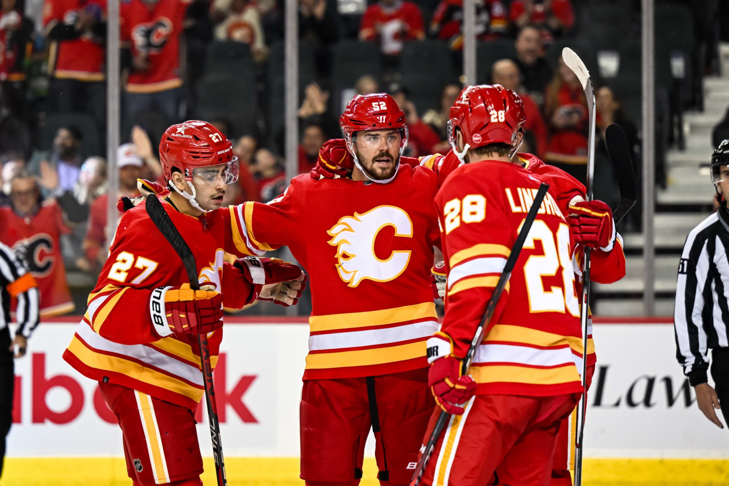 CALGARY, AB - NOVEMBER 01: Calgary Flames Defenceman MacKenzie Weegar (52) celebrates a goal with Calgary Flames Right Wing Matthew Coronato (27), Calgary Flames Left Wing Jonathan Huberdeau (10) and Calgary Flames Center Elias Lindholm (28) during the third period of an NHL game between the Calgary Flames and the Dallas Stars on November 1, 2023, at the Scotiabank Saddledome in Calgary, AB. (Photo by Brett Holmes/Icon Sportswire via Getty Images)