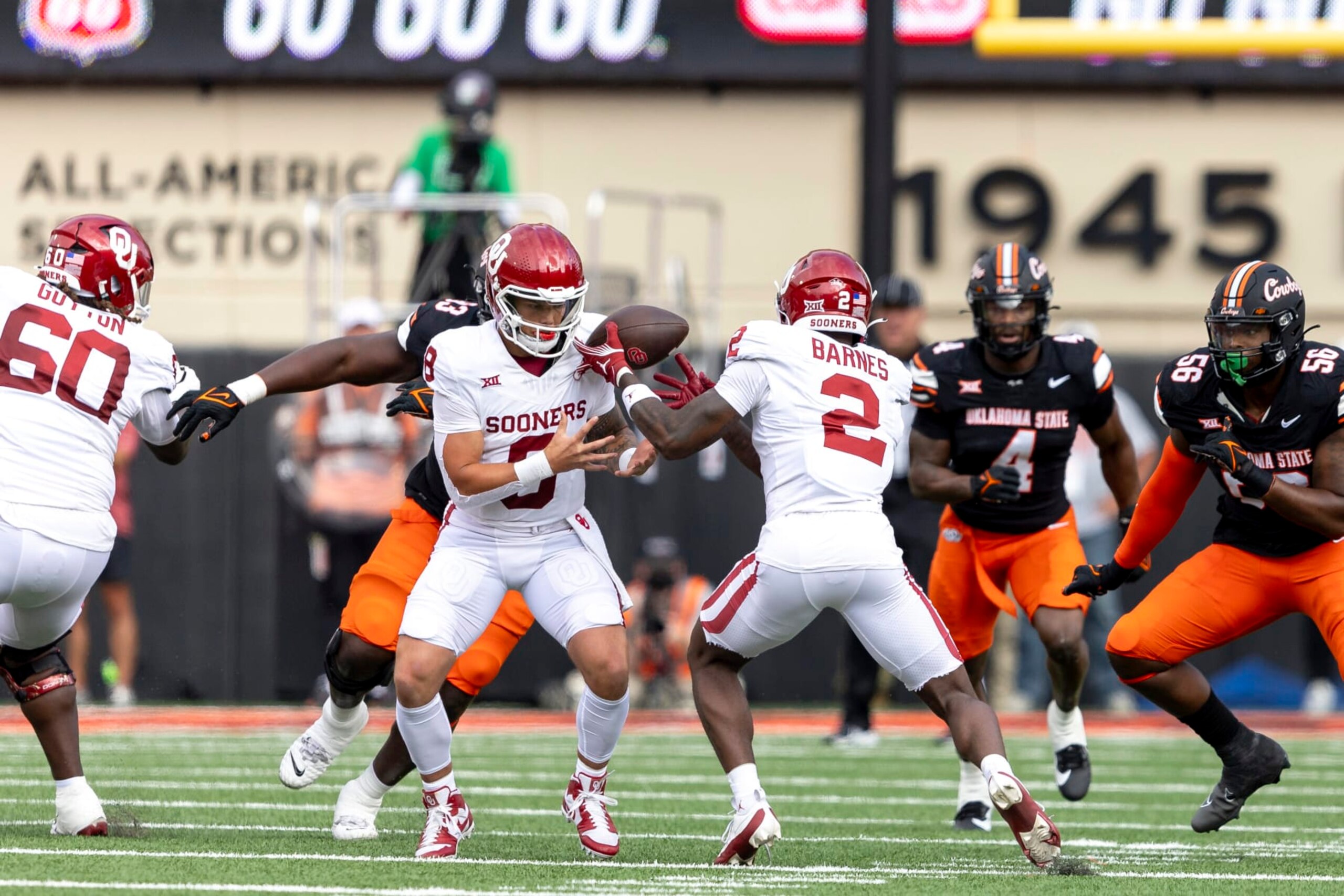 Oklahoma quarterback Dillon Gabriel (8) fumbles the ball while handing it off to running back Jovantae Barnes (2) in the first half of an NCAA college football game against Oklahoma State Saturday, Nov. 4, 2023, in Stillwater, Okla. (AP Photo/Mitch Alcala)